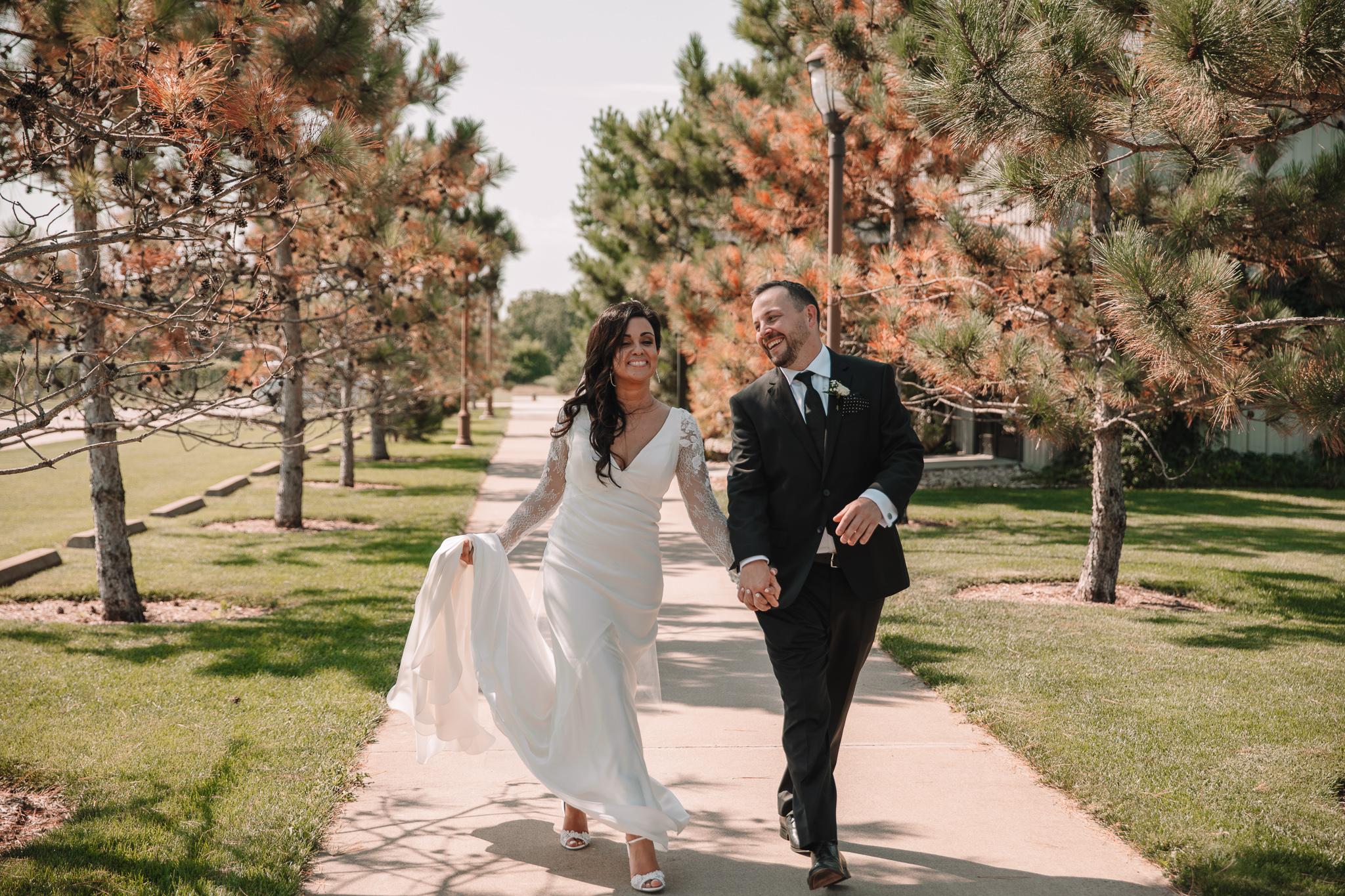 Bride and Groom walking happily down the street laughing holding hands