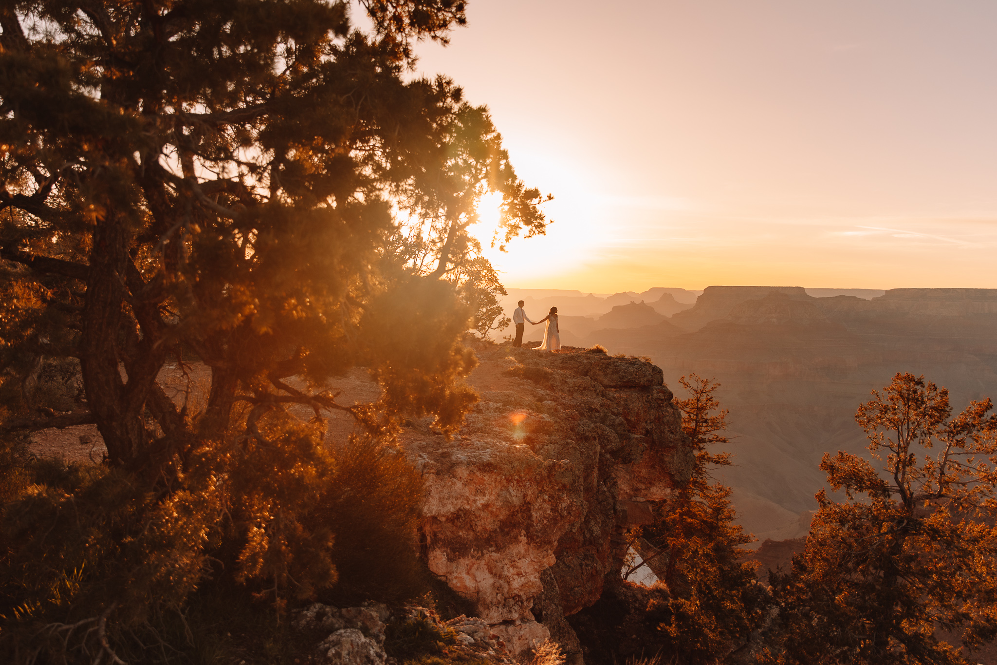 Elopement couple walking on the edge of a cliff in The Grand Canyon
