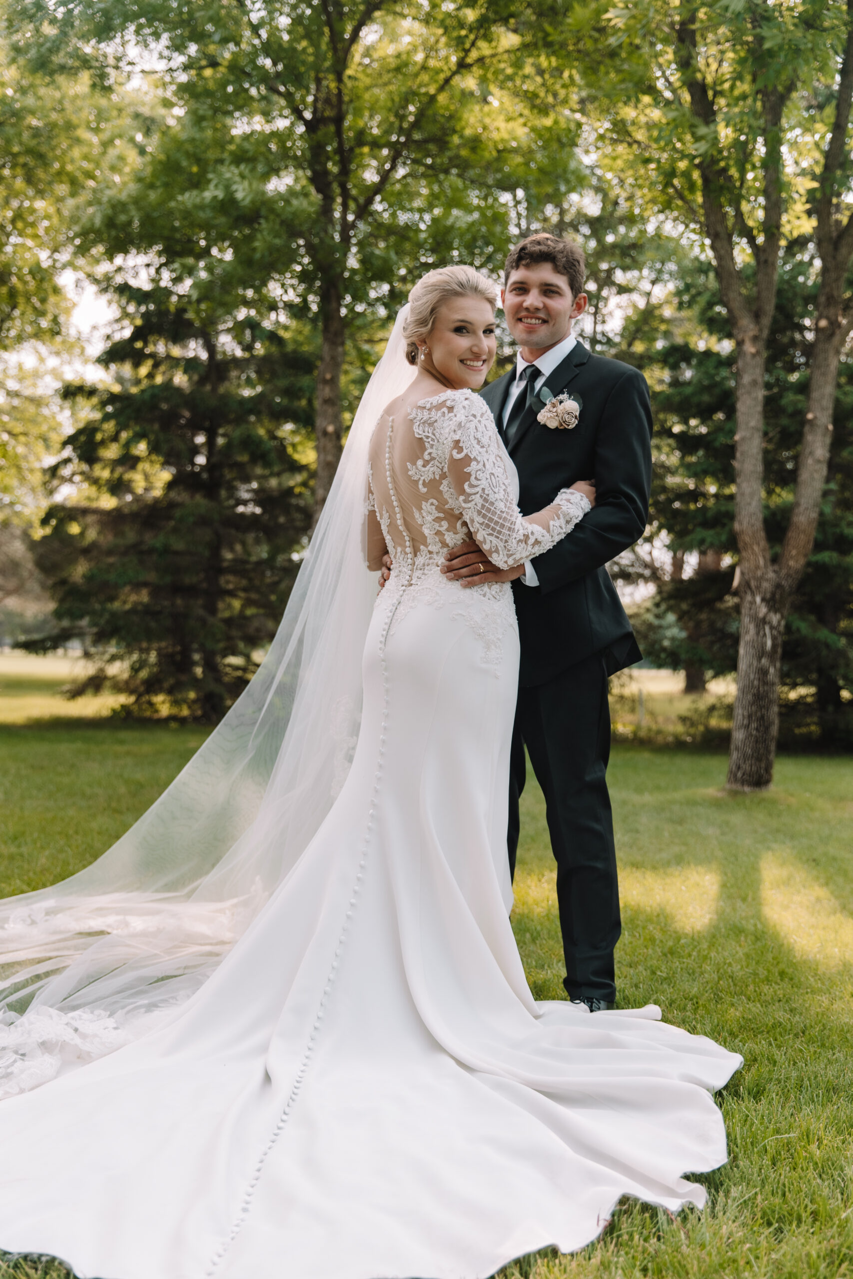 Bride and Groom Portrait photo with bride's beautiful long train and open back lace wedding dress after their first look