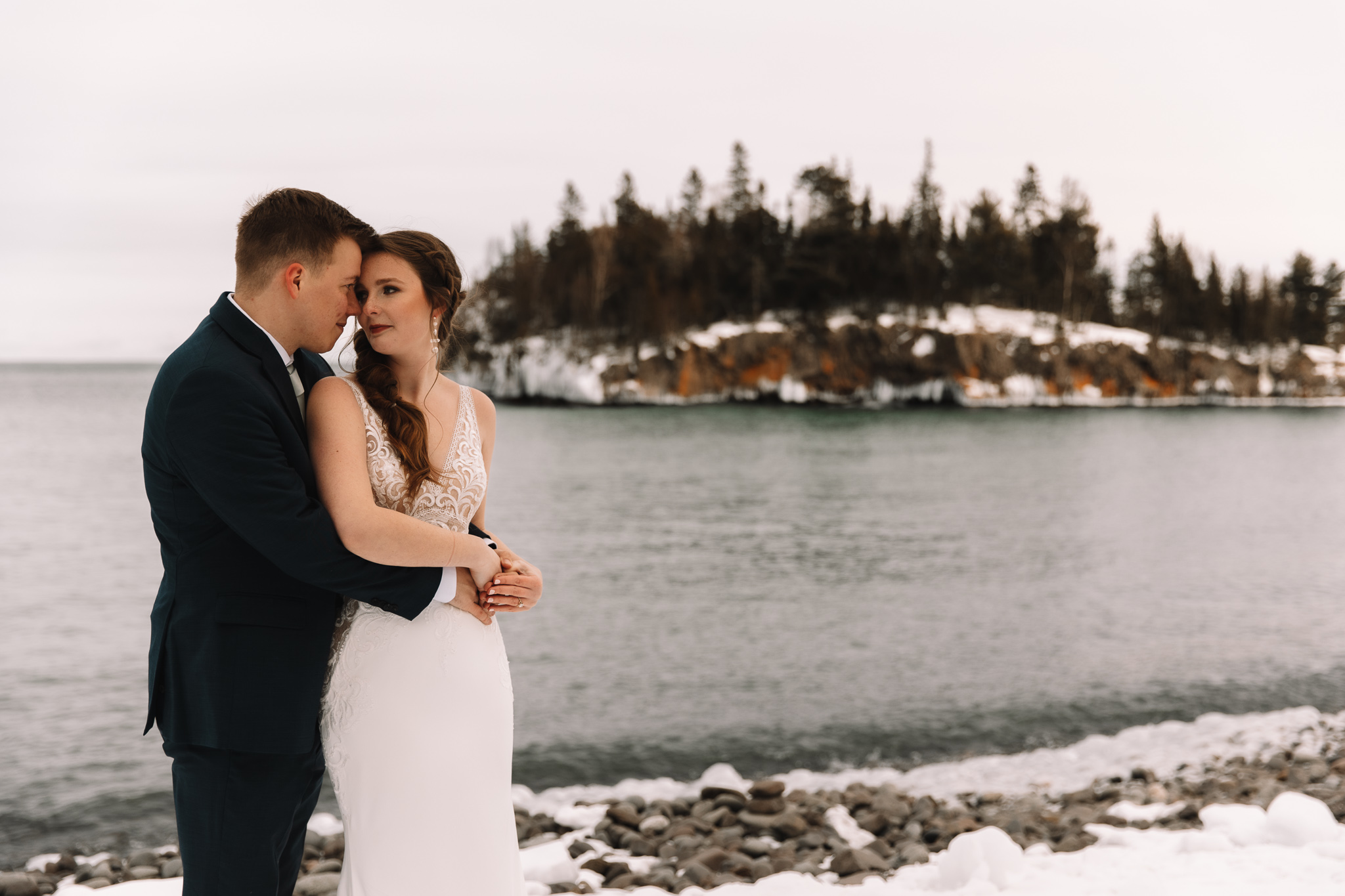 Groom holding his bride tenderly on silver bay in Minnesota. 