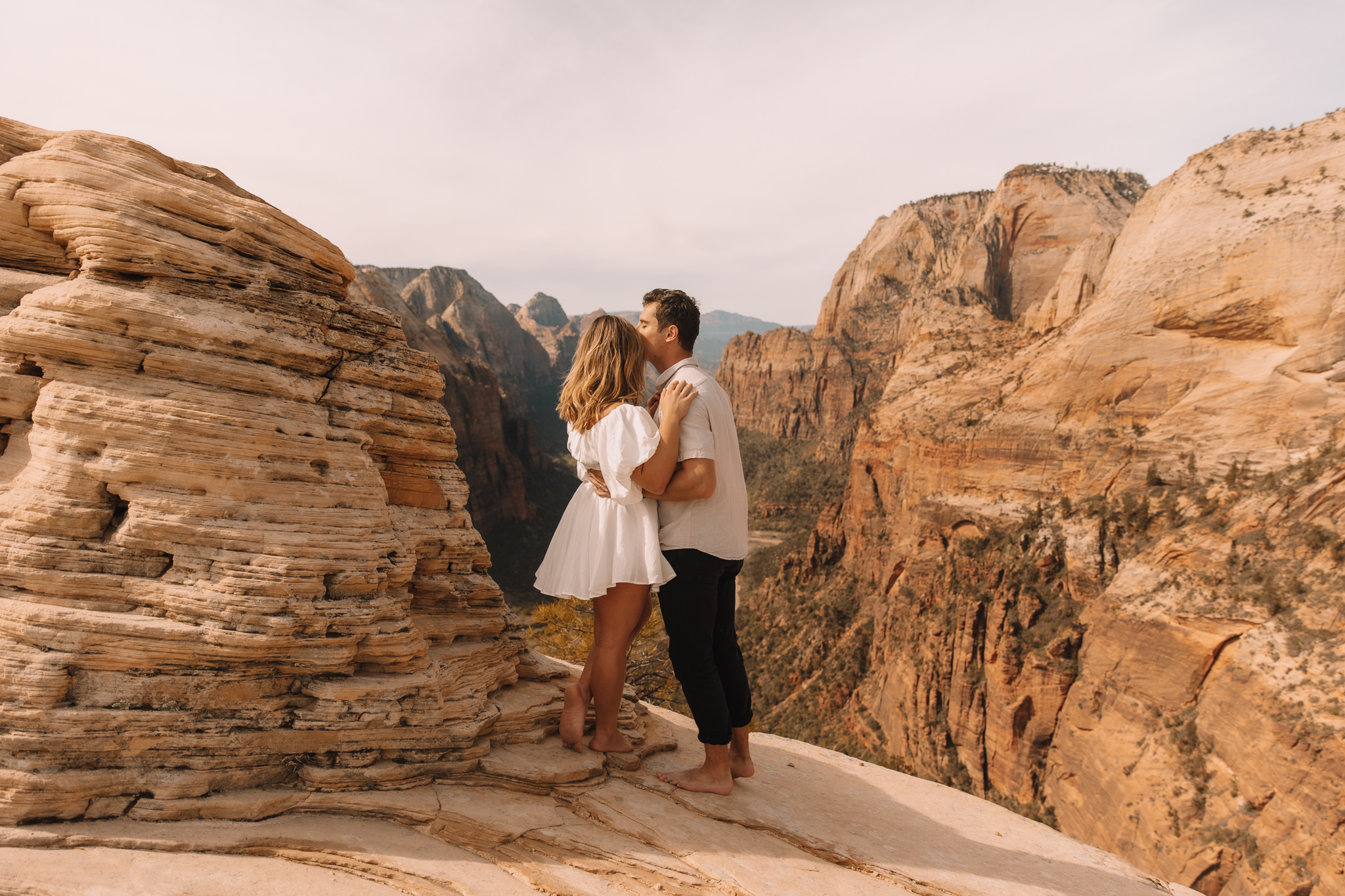 Elopement couple standing at the top of Angel's Landing overlooking the views in Zion National Park