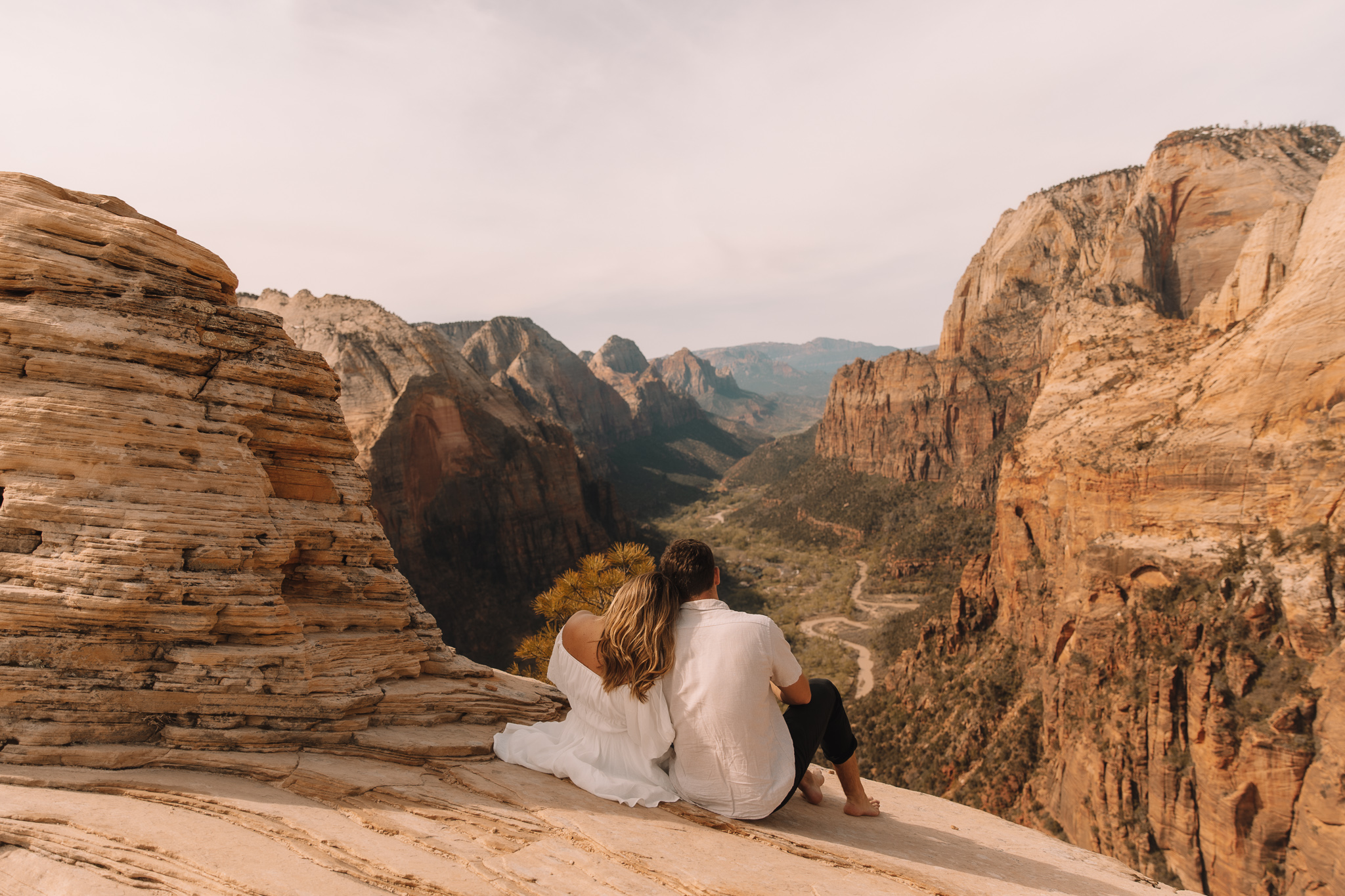 Elopement Couple siting on a cliff at the Top of Angel's Landing in Zion National Park