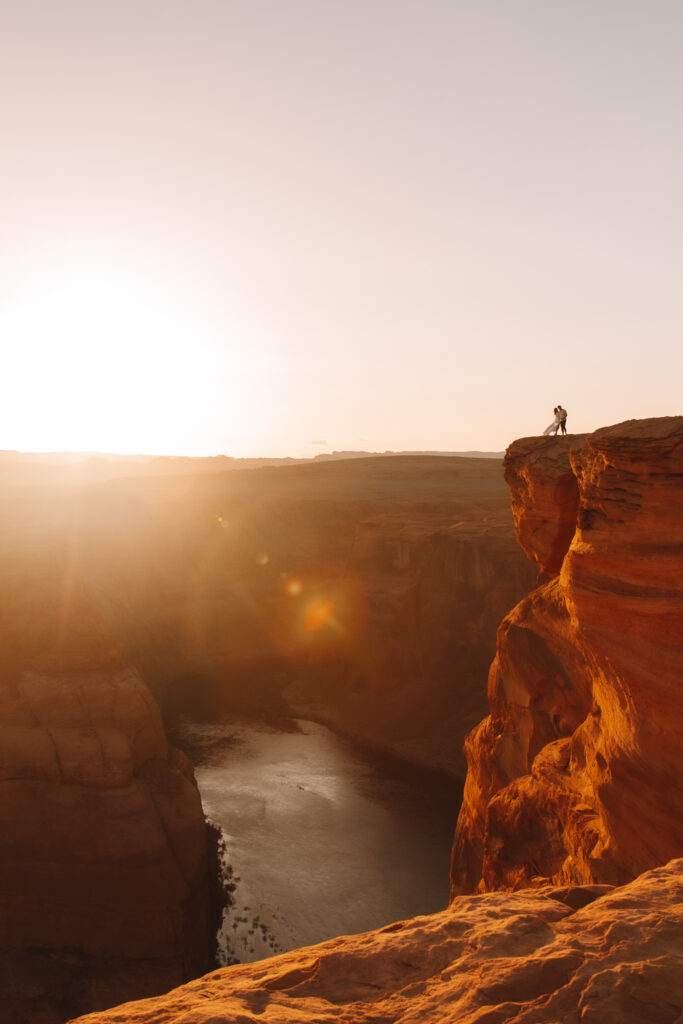 Horseshoe Bend elopement couple in Page, Arizona standing on a cliff overlooking the canyon