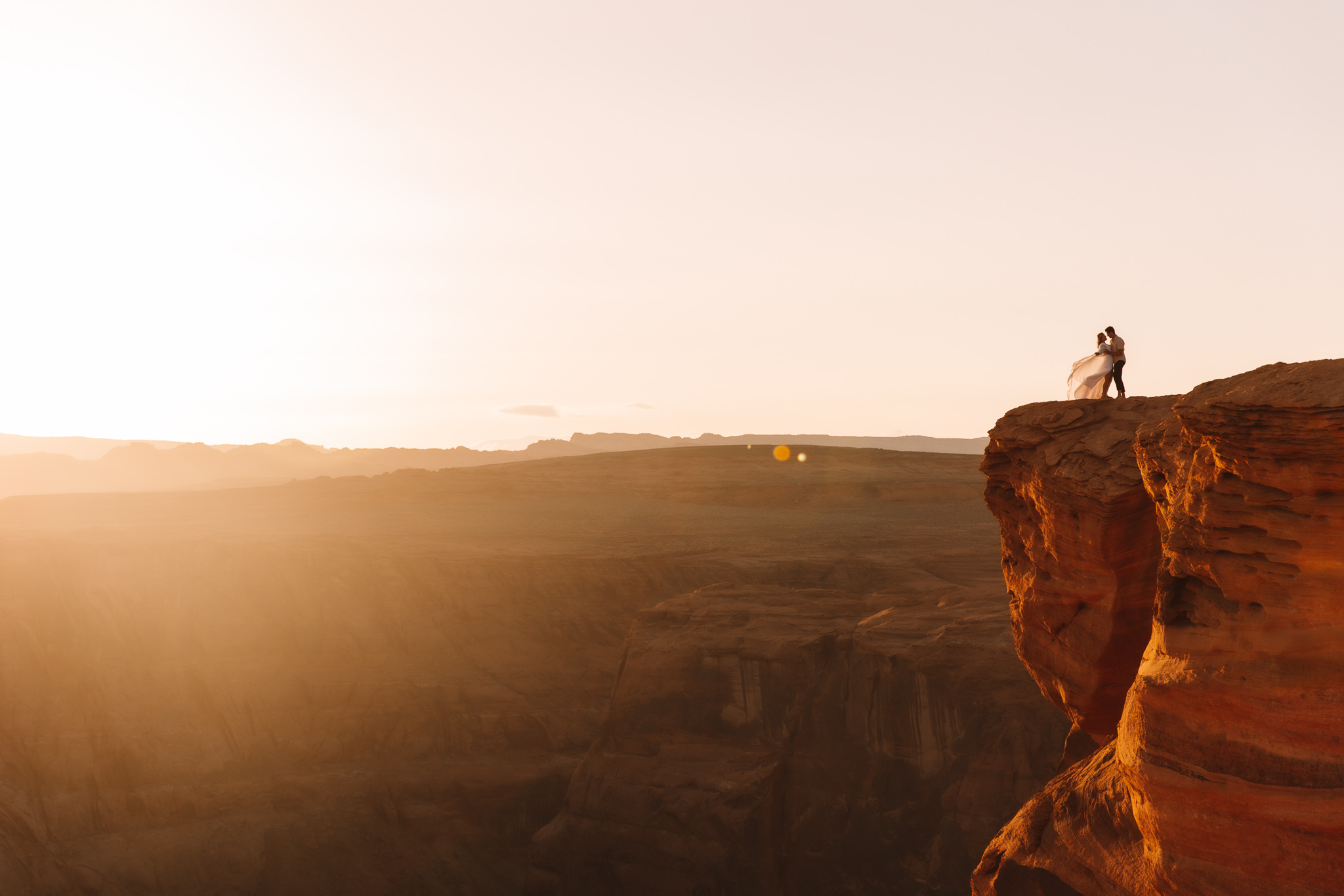 Horseshoe bend Elopement couple standing on the edge of a cliff during sunset