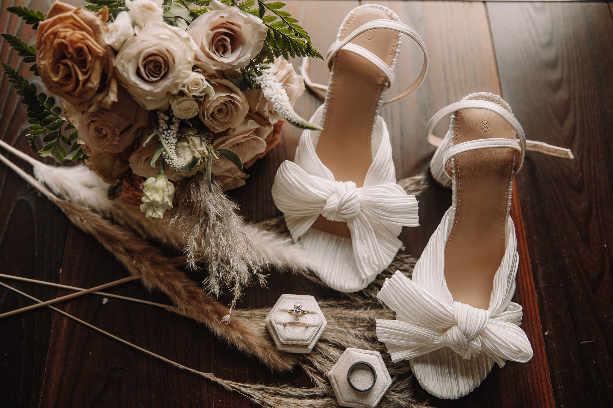 Flat lay and detail photo of bridal shoes, bouquet and ring for wedding couple in North Dakota