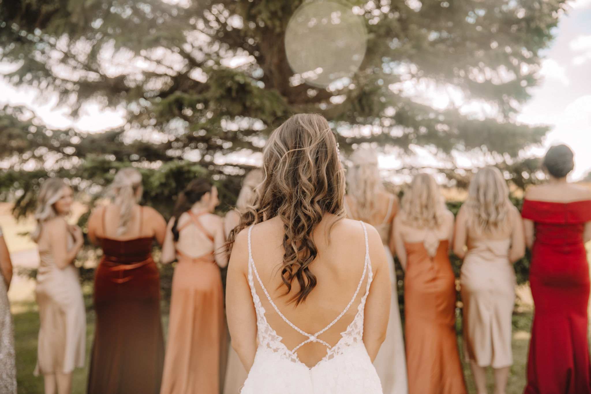 North Dakota Bride getting ready for her reveal to her bridesmaids in their fall colored dresses