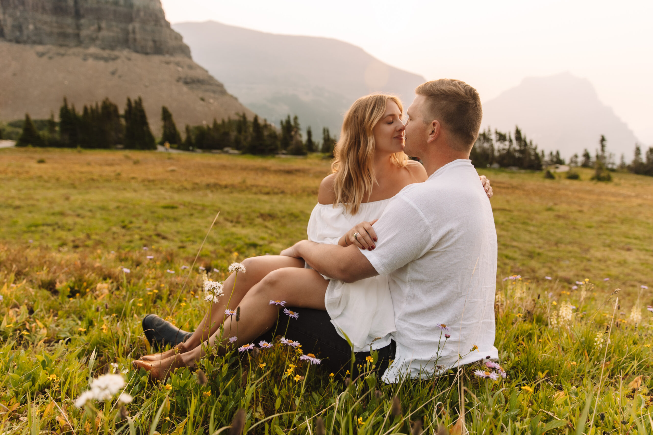 Elopement Couple sitting between the flowers at Logan's Pass in Glacier National Park