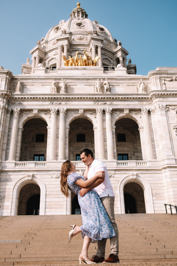 Engagement couple dip kissing in front of the Minnesota State Capitol- One of the best engagement photo locations in Minneapolis