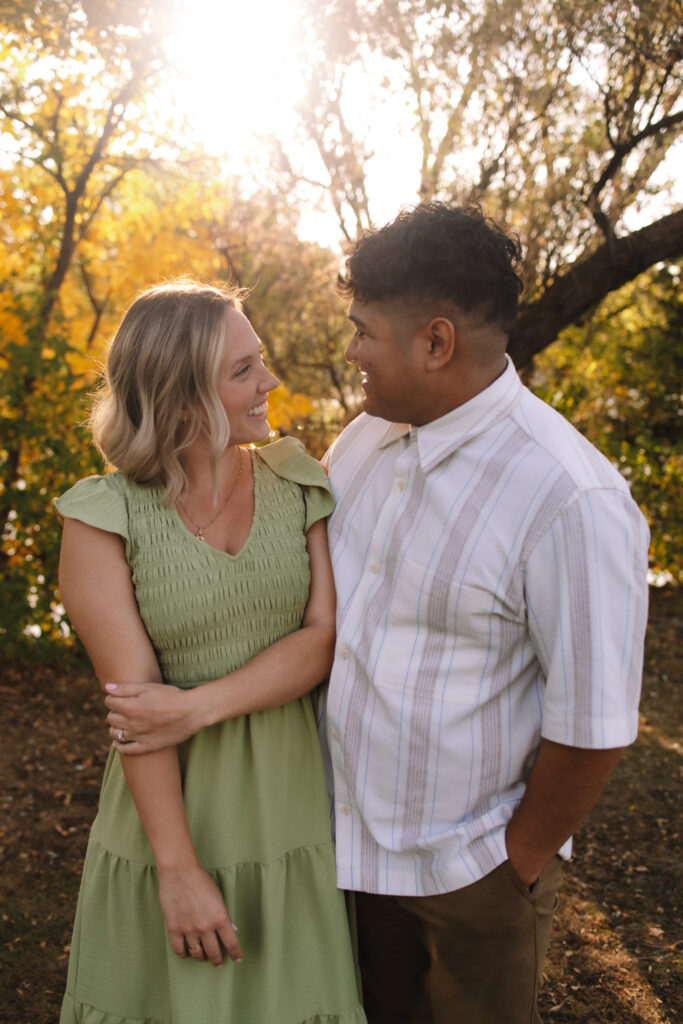 Engagement couple standing side by side staring into each other's eyes at Boom Island Park in Minneapolis - one of the best engagement photo locations in Minneapolis