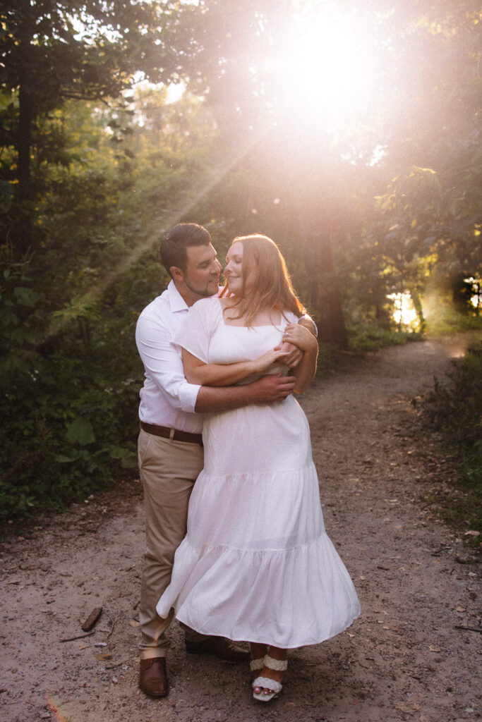 Guy twirling his beautiful fiancé as the sun sets behind them at Minihaha Falls in Minneapolis- One of the best engagement photo locations in Minneapolis