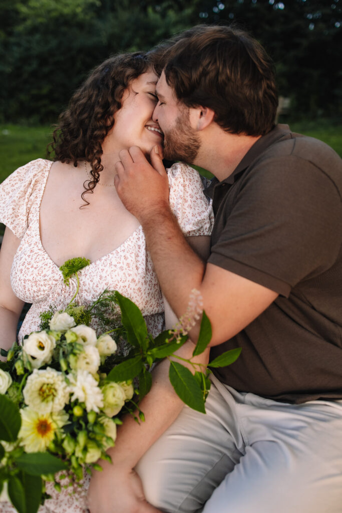 Guy grabbing his girl's face tenderly as he leans in for a kiss