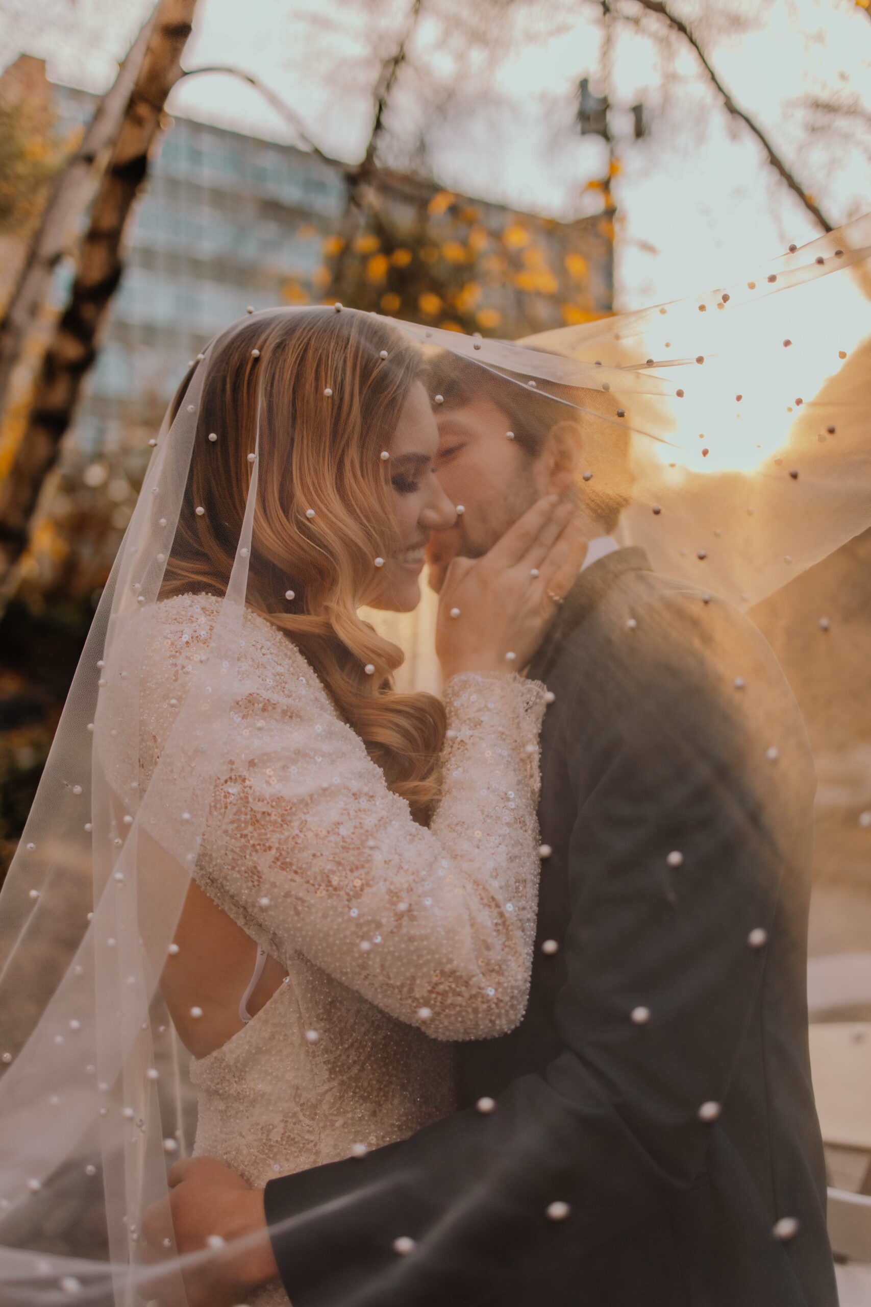 Stunning pearl veil shot of wedding couple during sunset in Minneapolis