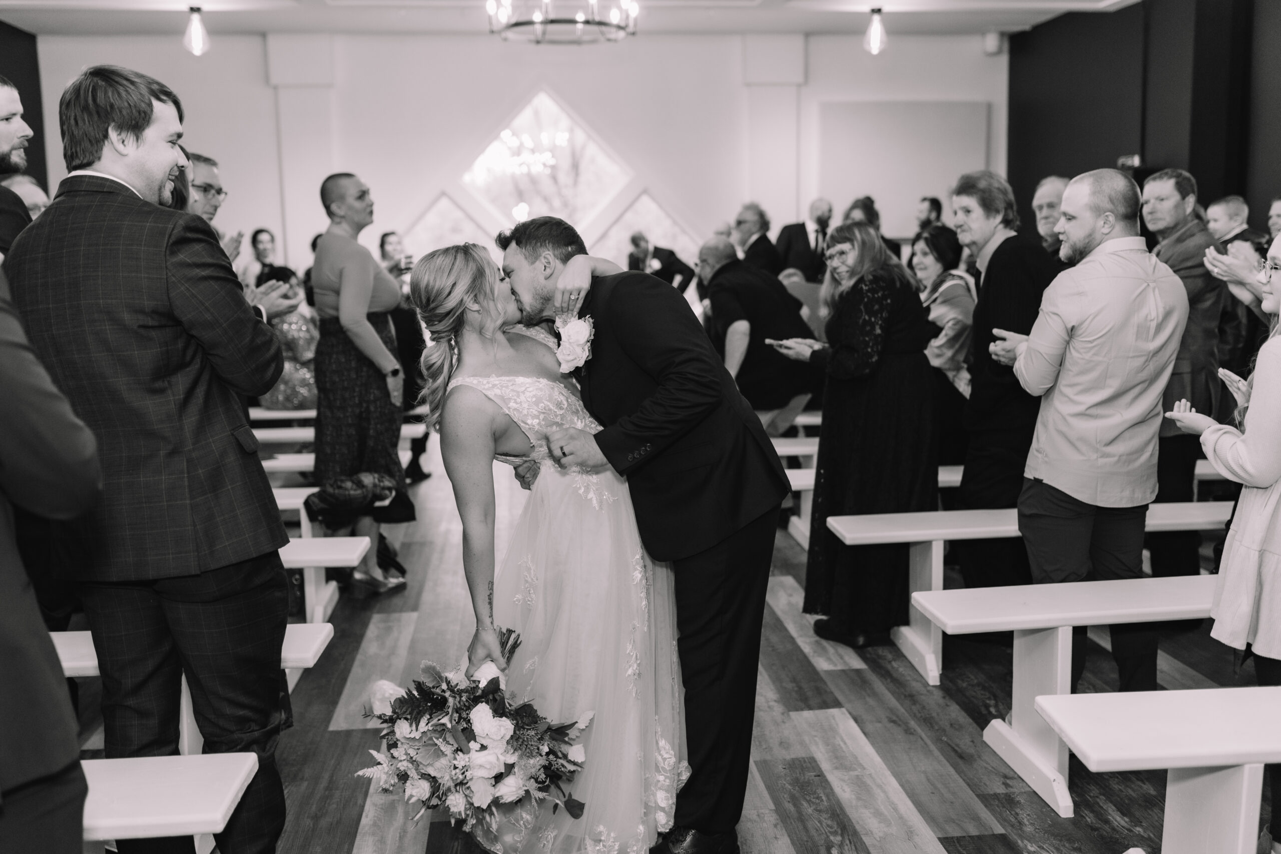 Bride and Groom dip kiss down the aisle at the indoor ceremony space at Ahavah Cottage Wedding venue