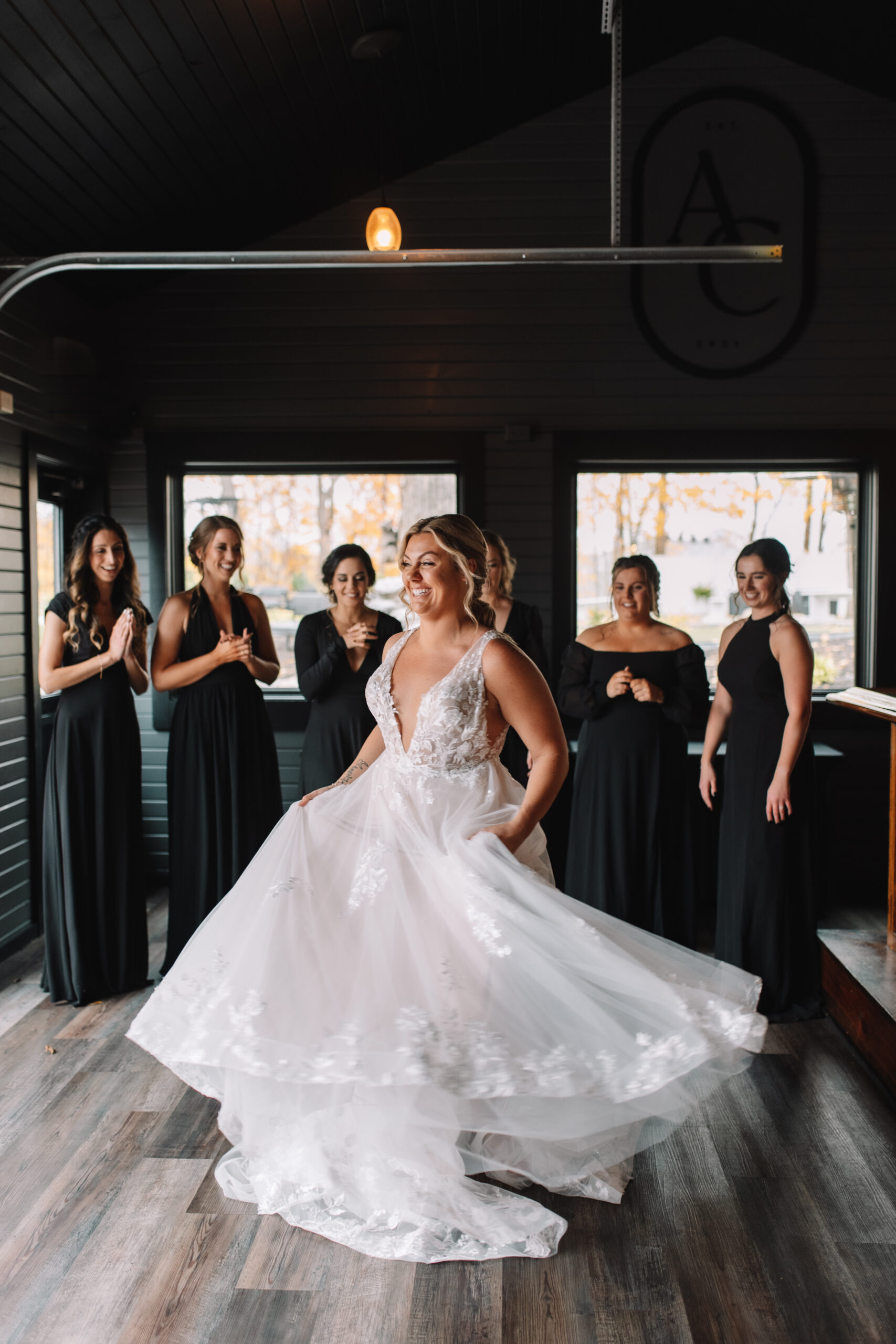 Bride revealing her dress to bridesmaids at Ahavah Cottage Wedding Venue in Minnesota