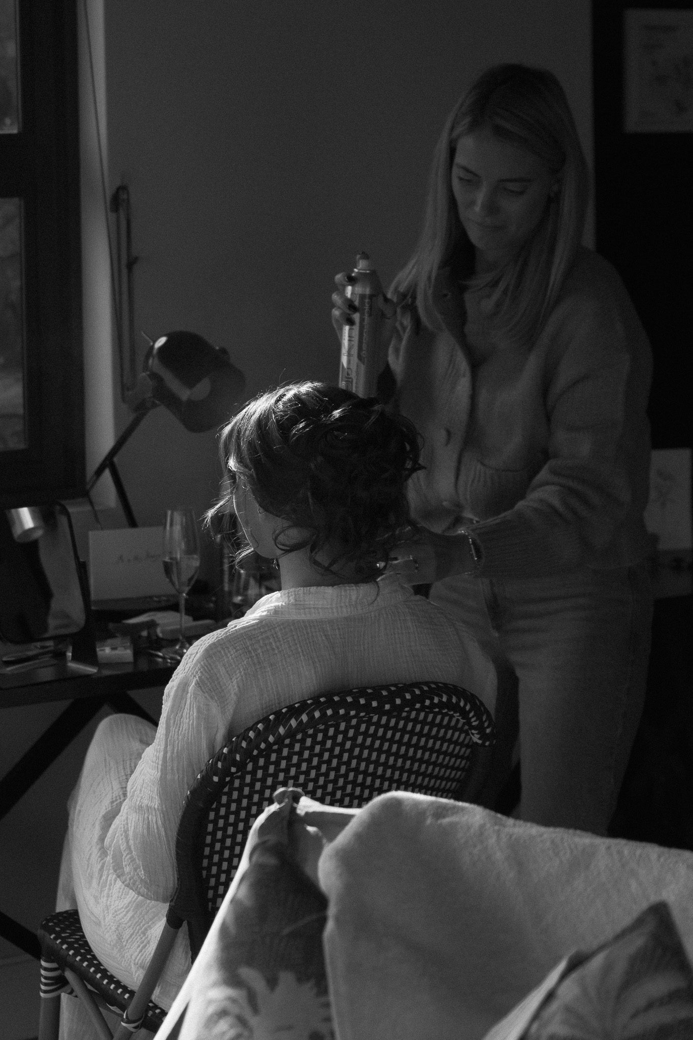 Bride having her hair styled inside a safari lodge suite before her elopement