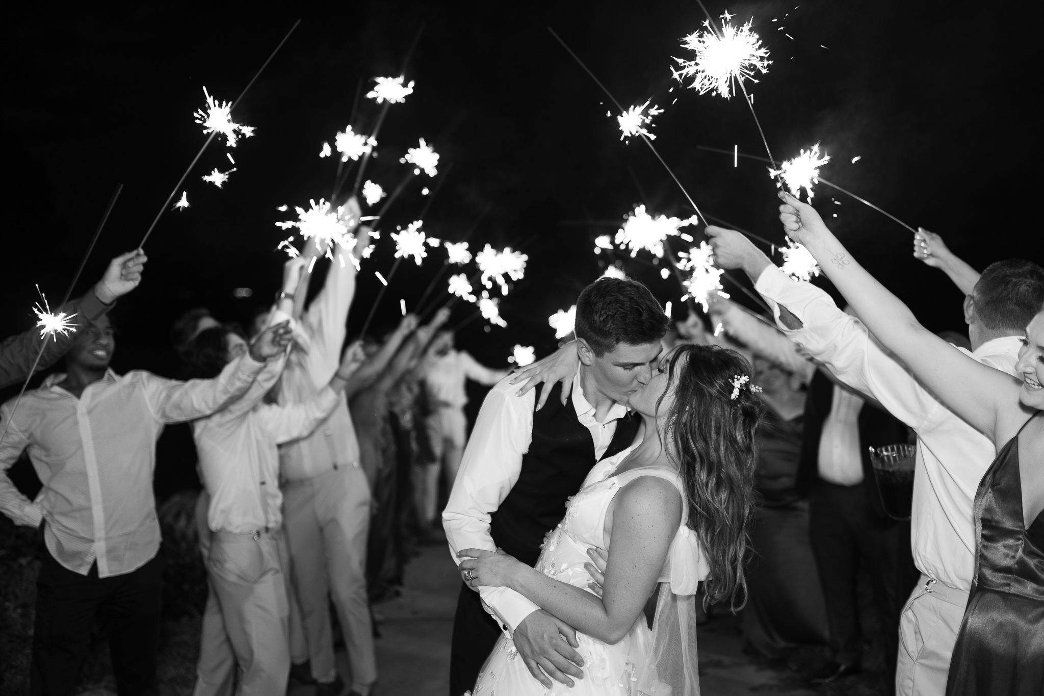 Wedding day sparkler exit shot of Bride & groom kissing at the end of the tunnel
