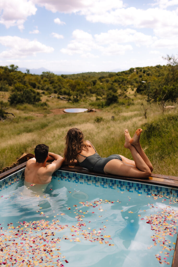 Elopement couple relaxing by the pool at a safari lodge in South Africa 