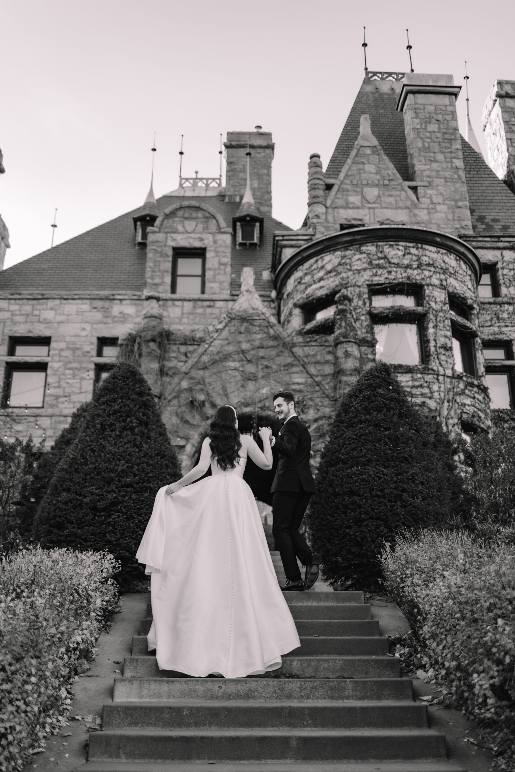 Groom leading his bride up the stairs to a beautiful castle wedding venue located in Minneapolis, Minnesota