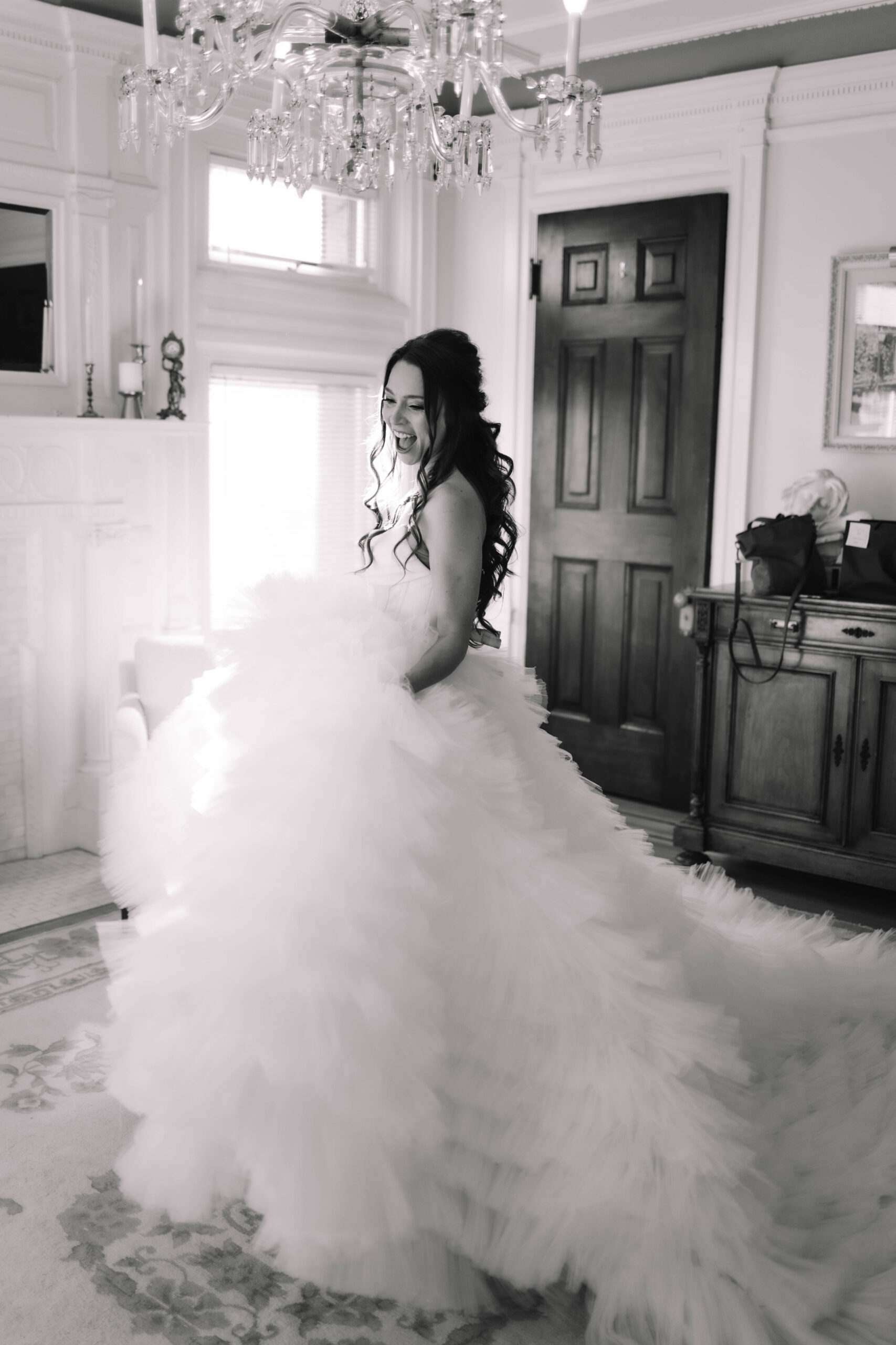 A bride swaying around in a voluptuous, ball gown dress in the bridal suite of the Van Dusen Mansion in Minneapolis, Minnesota