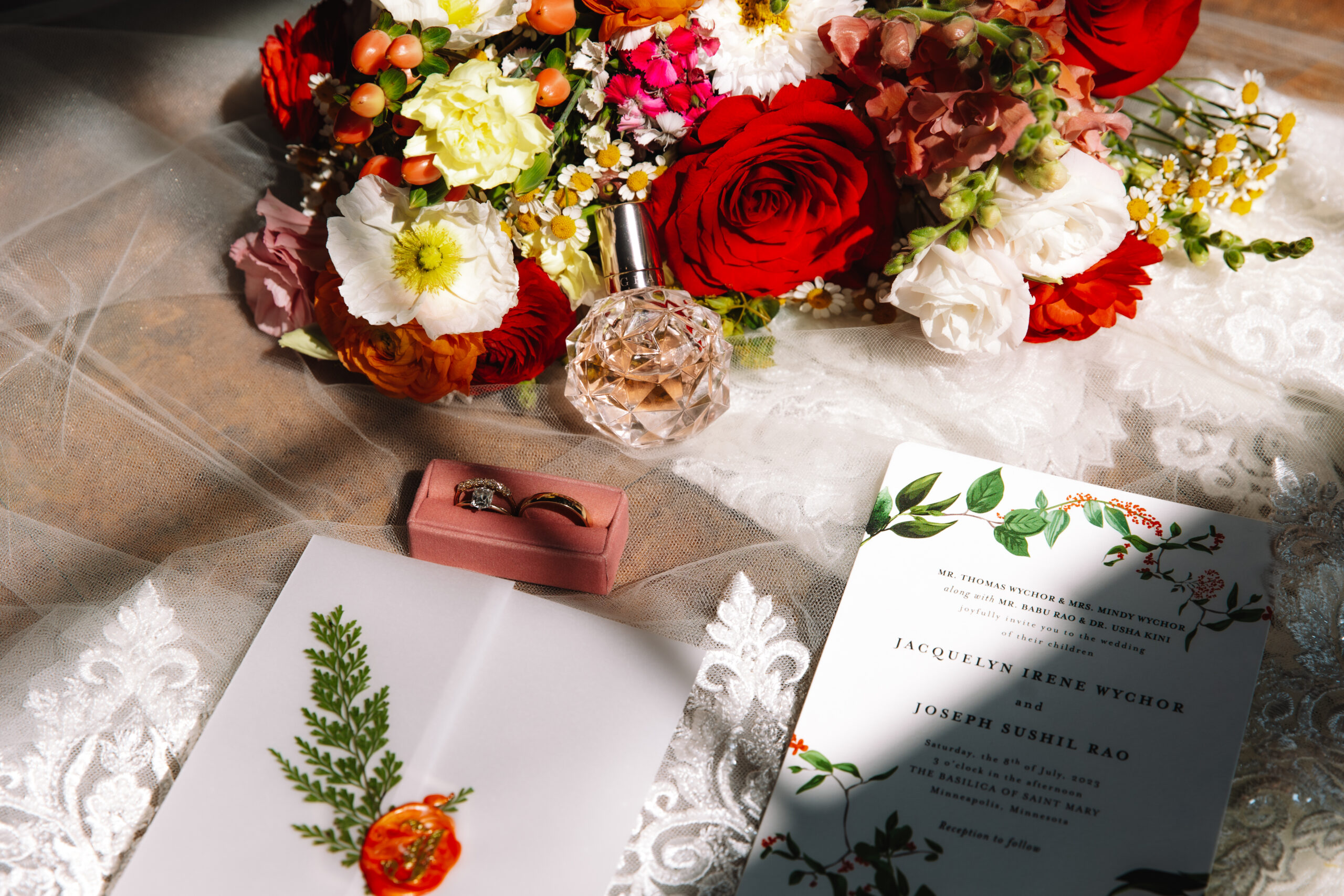 Colorful wedding flat lay details of bouquet, perfume, invites, rings and veil