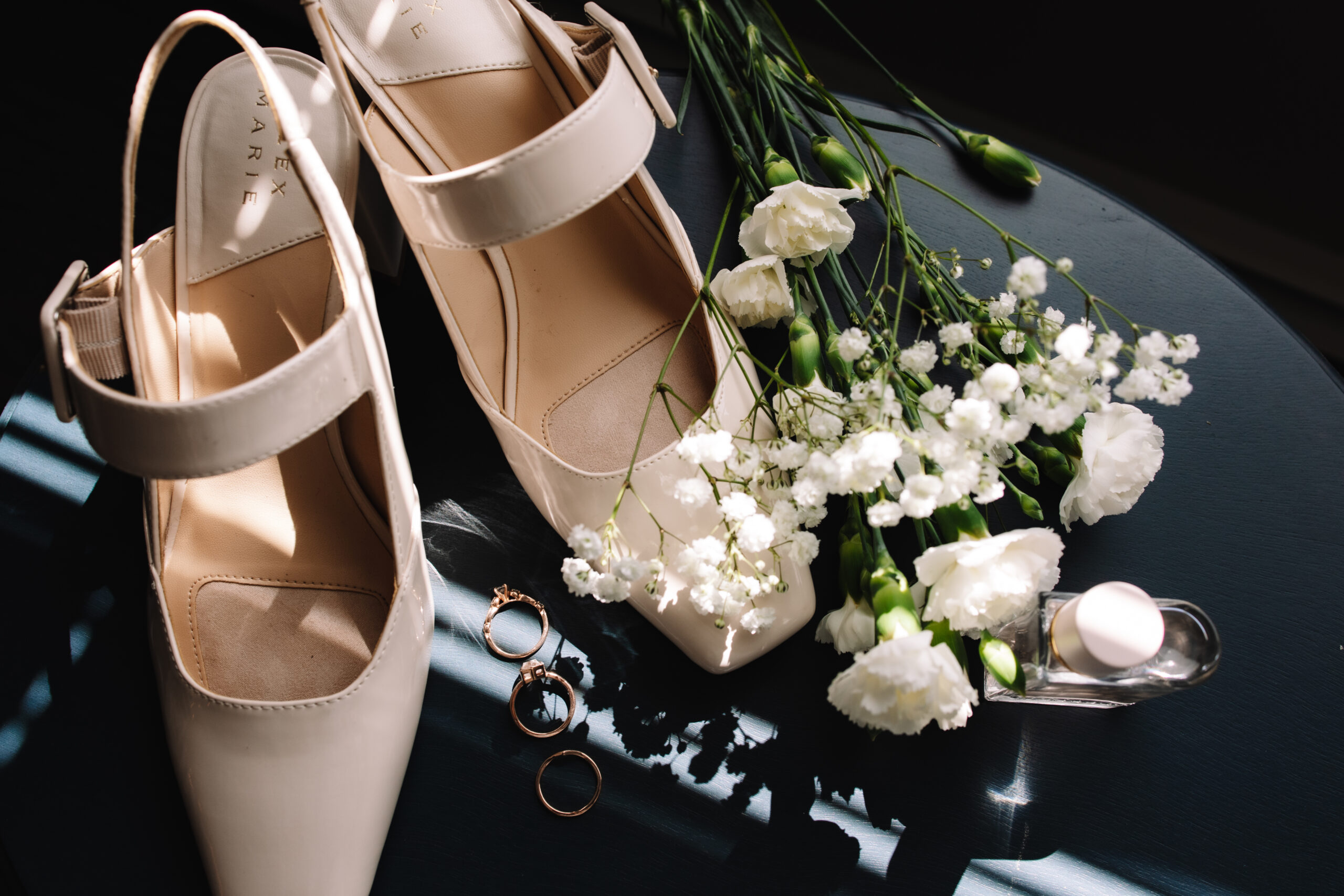 Beautiful, simple wedding day details, including wedding heels, white flowers and rings