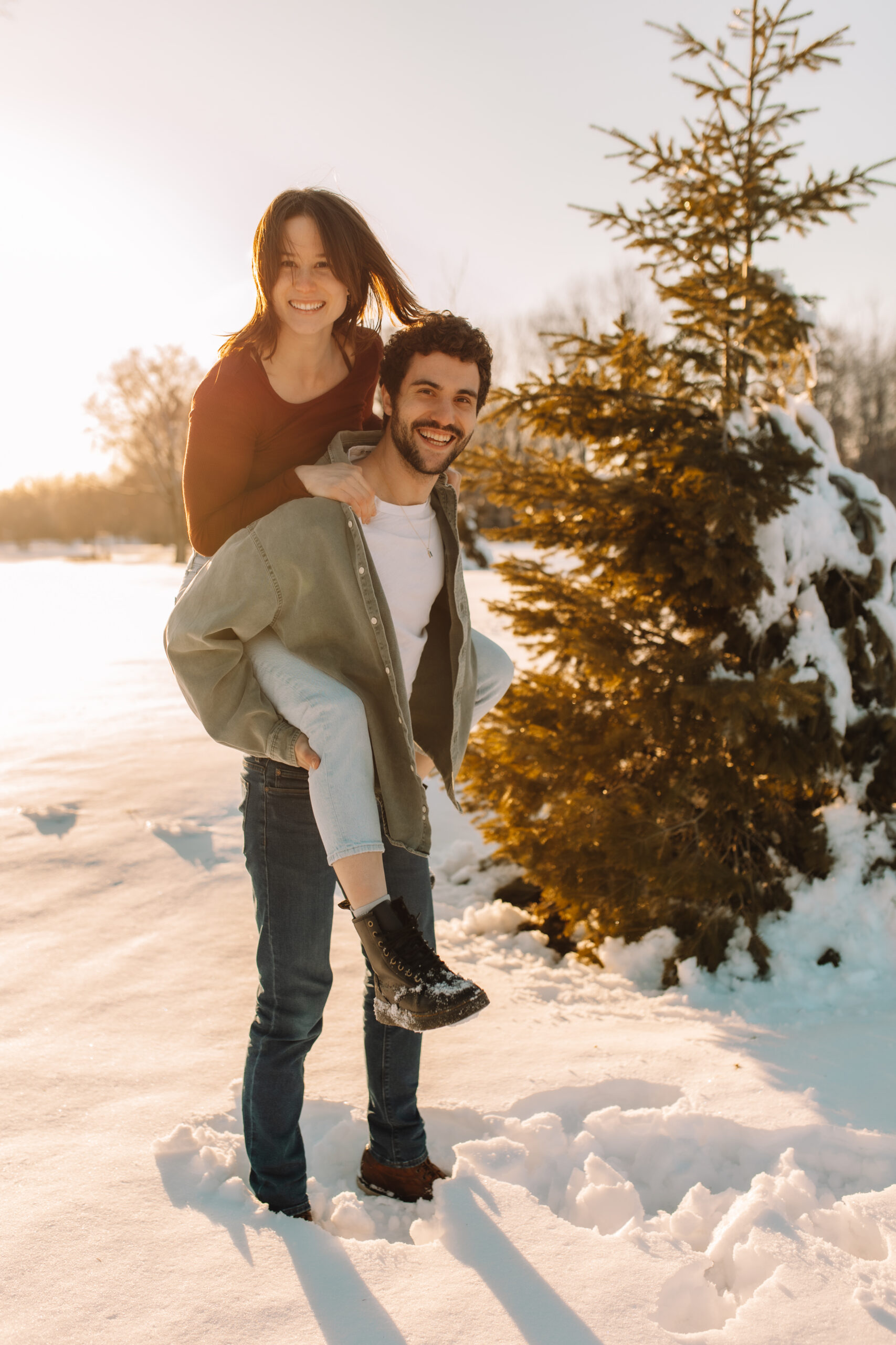 Fiance holding soon to be wife on his back giving her a piggy back