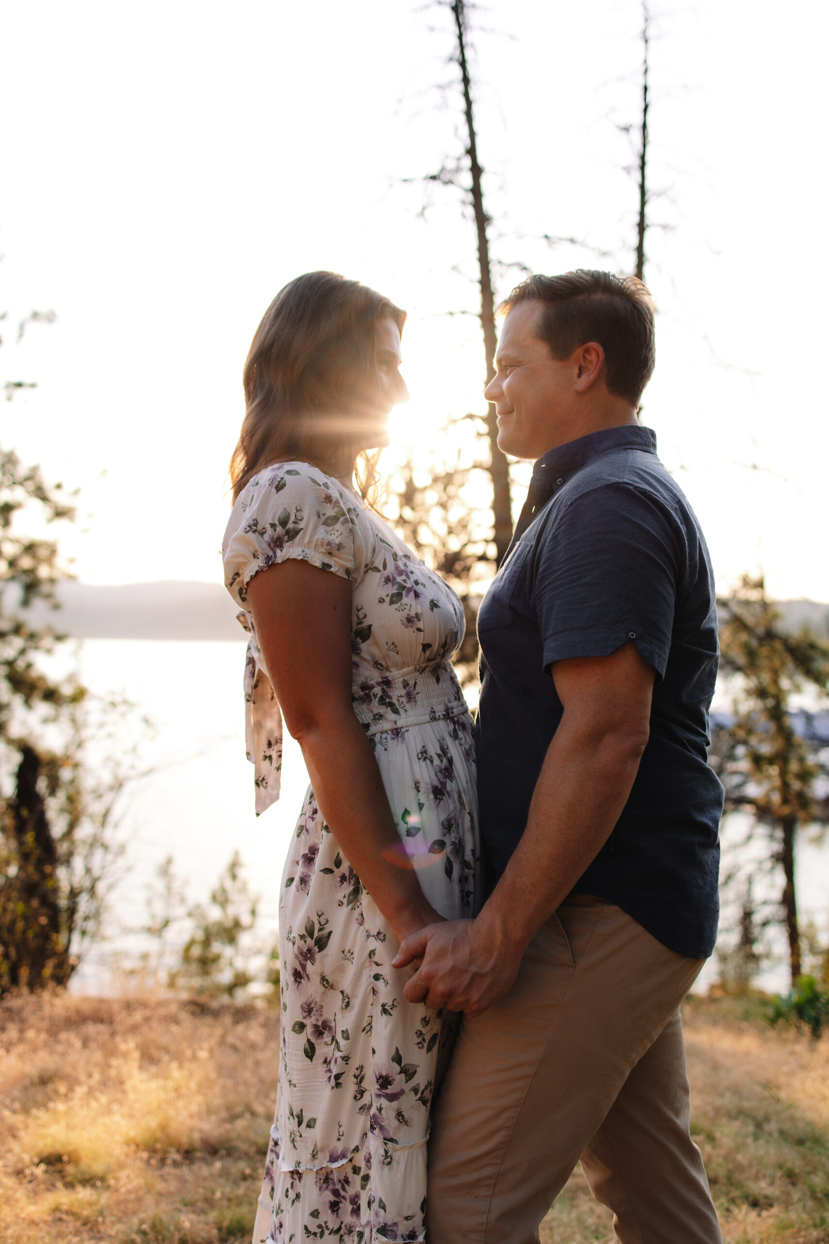 Engagement couple standing chest to chest entangled during sunset with the perfect example of what to wear for your engagement photos in Minnesota 