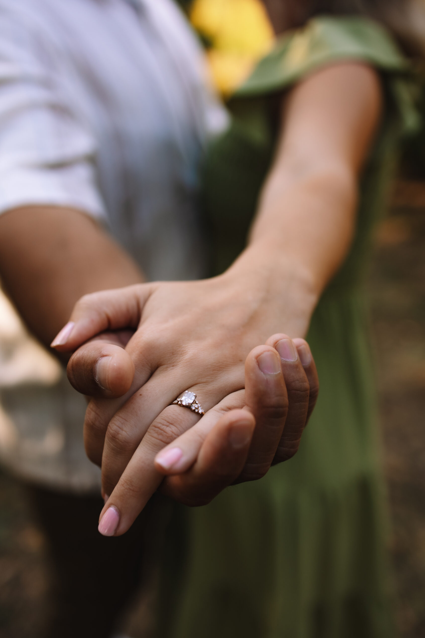 close up of an engagement couple's hands with a beautiful ring on the girl's hand