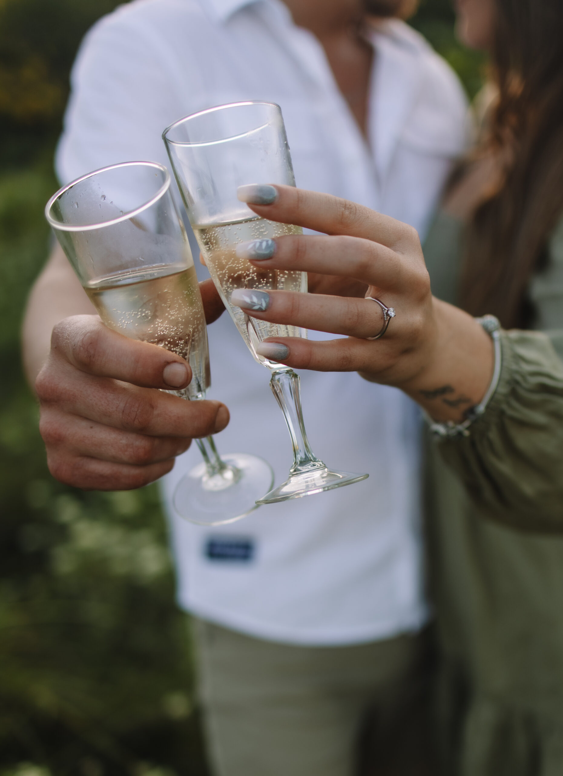 Newly engaged couple toasting champagne glasses