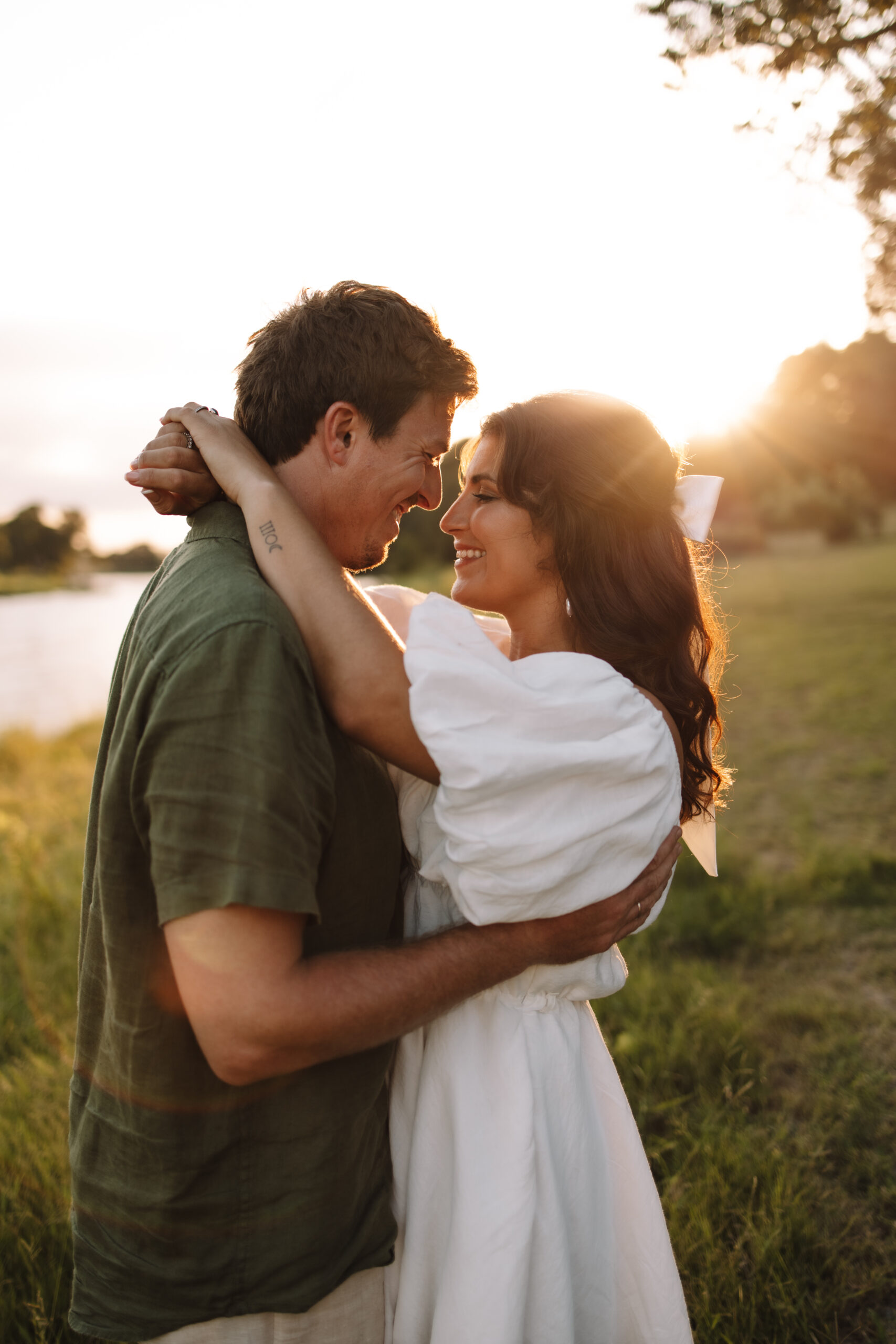 Engaged couple wearing cute, casual engagement outfits in a field of grass, perfect inspiration to help you on what to wear for your engagement photos in Minnesota