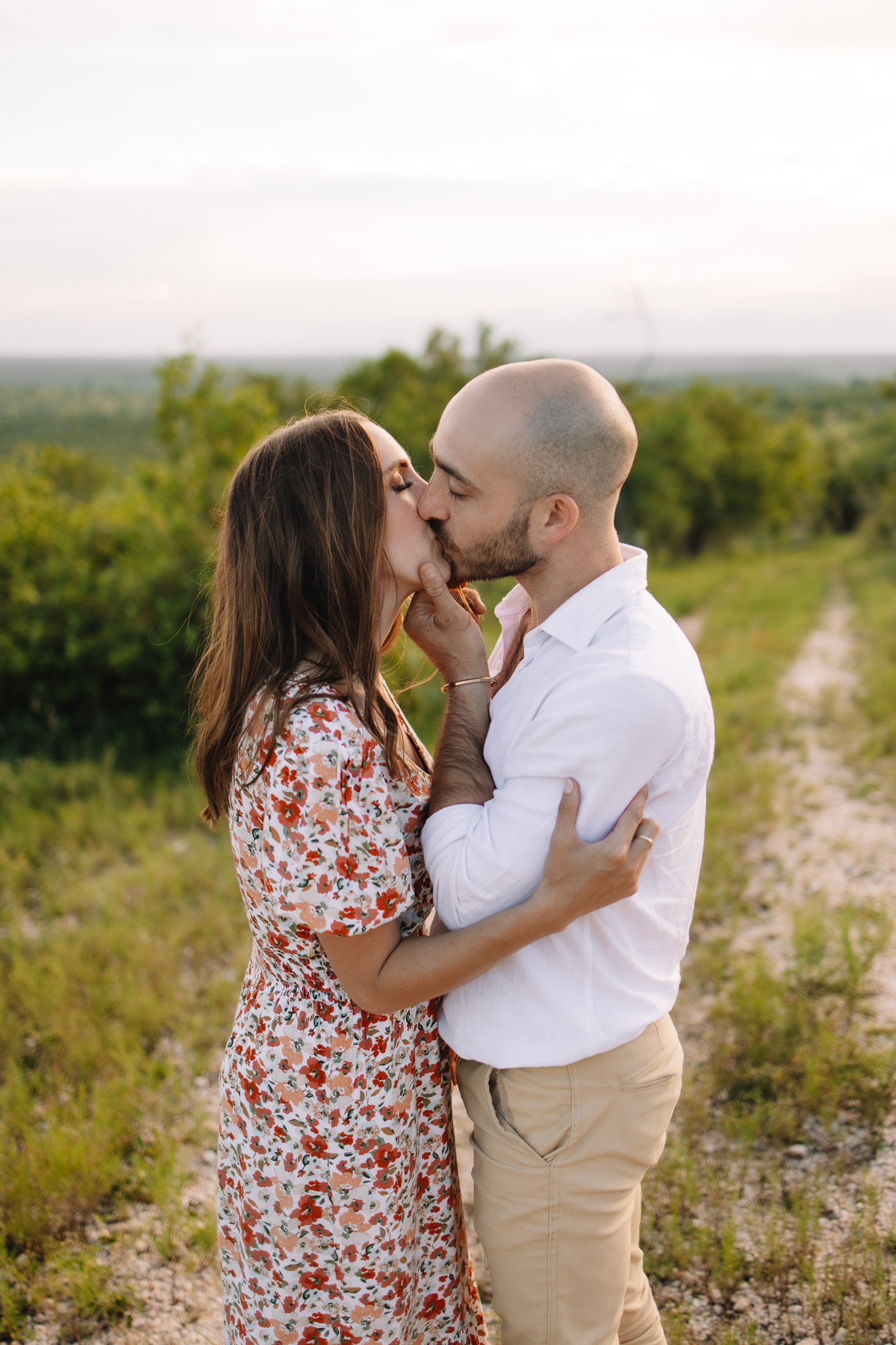 Engagement couple wearing a beautiful spring outfit. Spring floral dress for the lady and a white button up shirt with beige pants for the guys