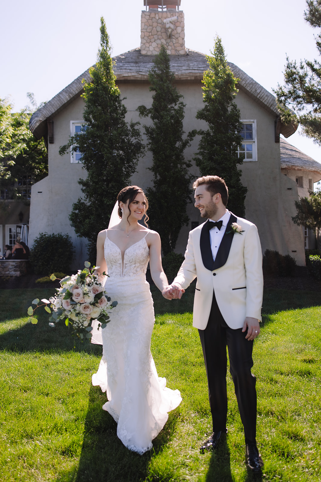 Bride and groom holding hands smiling at one another at Edward Anne Estate