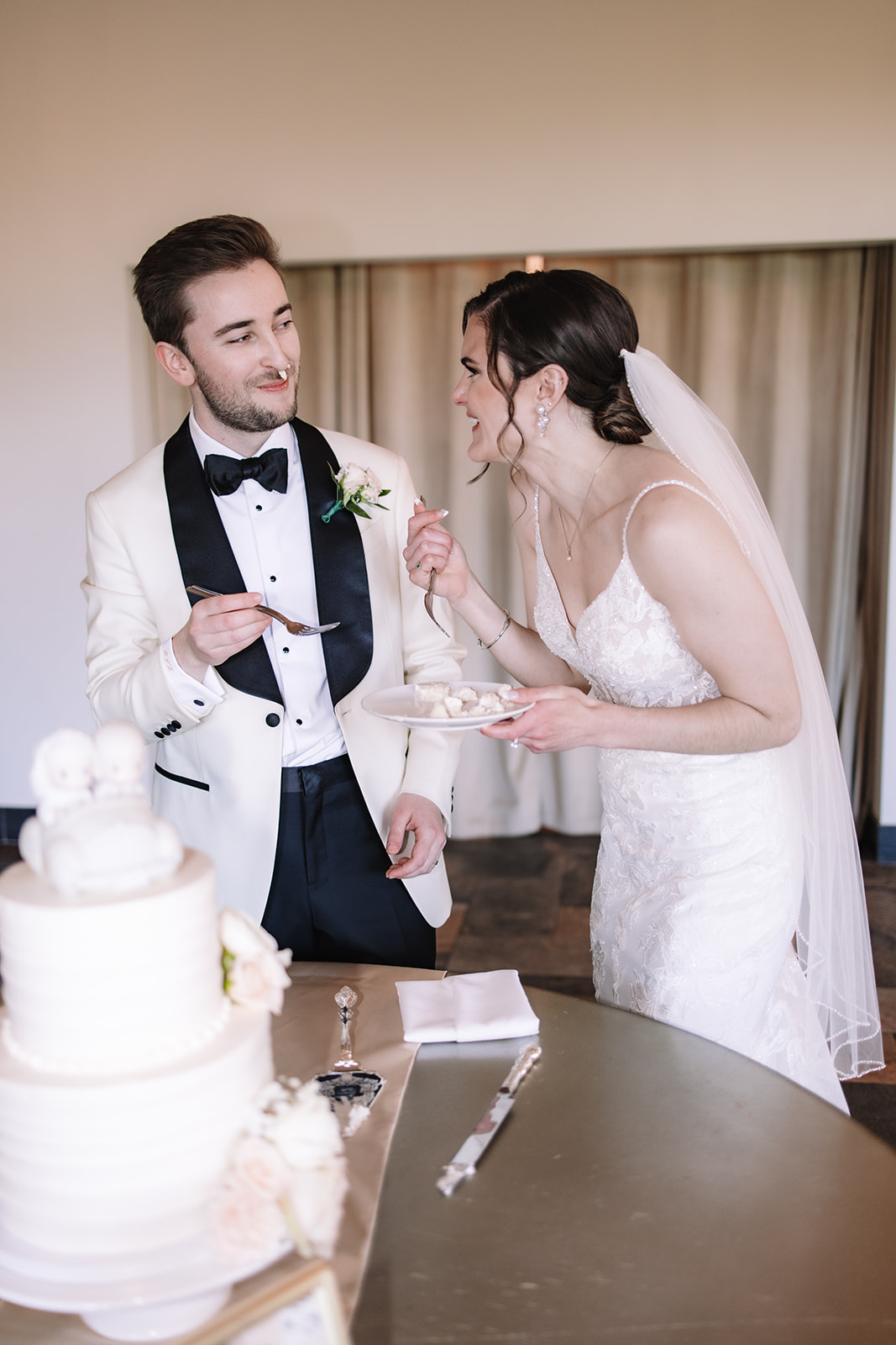 Bride and groom feeding each other wedding cake 