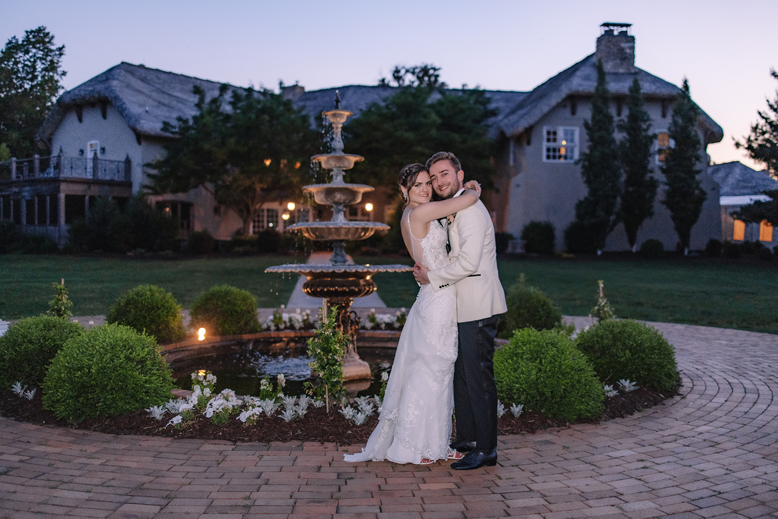 Bride and groom hugging one another smiling in front of Edward Anne Estate