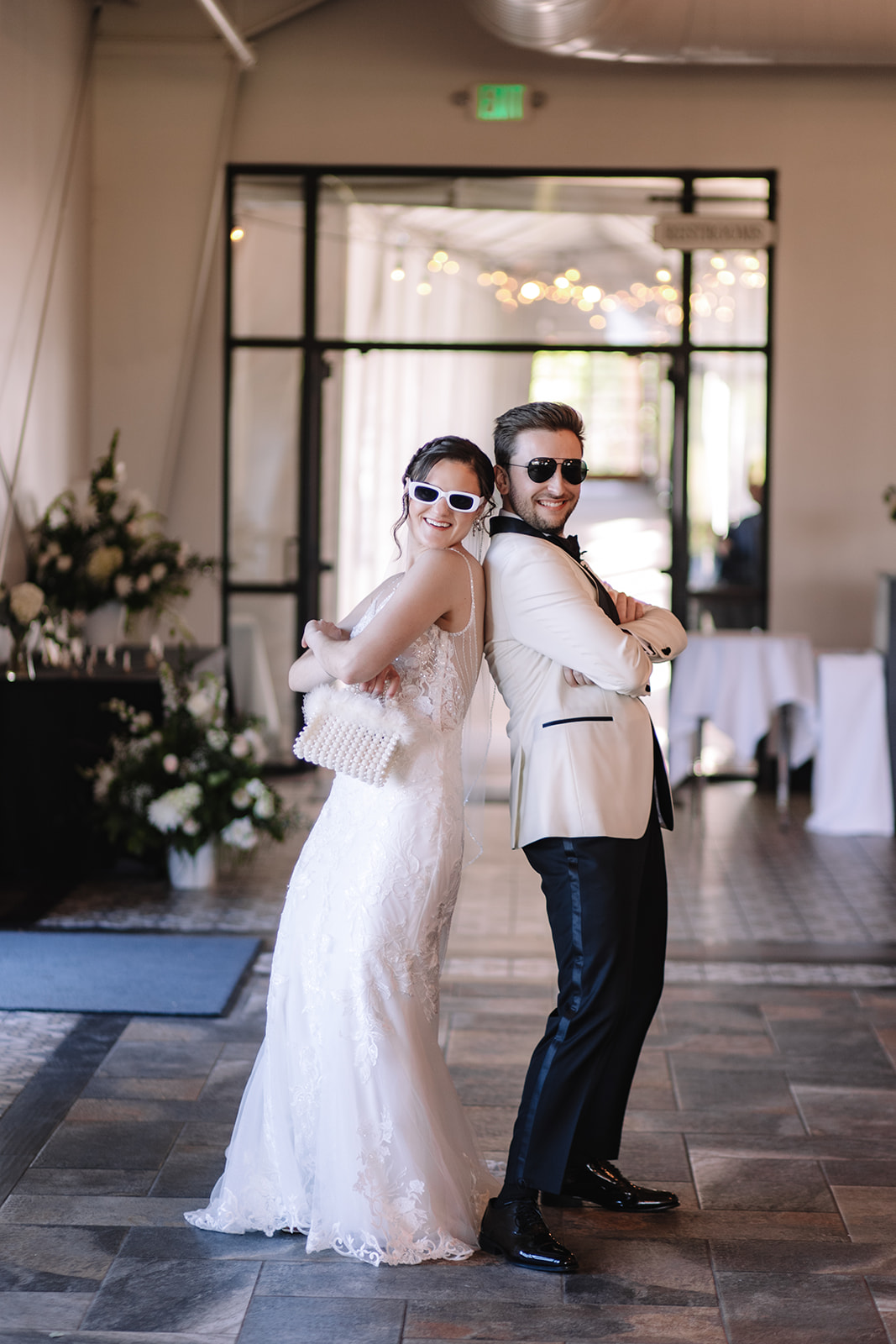 Bride and groom acting silly walking into the wedding reception space back to back