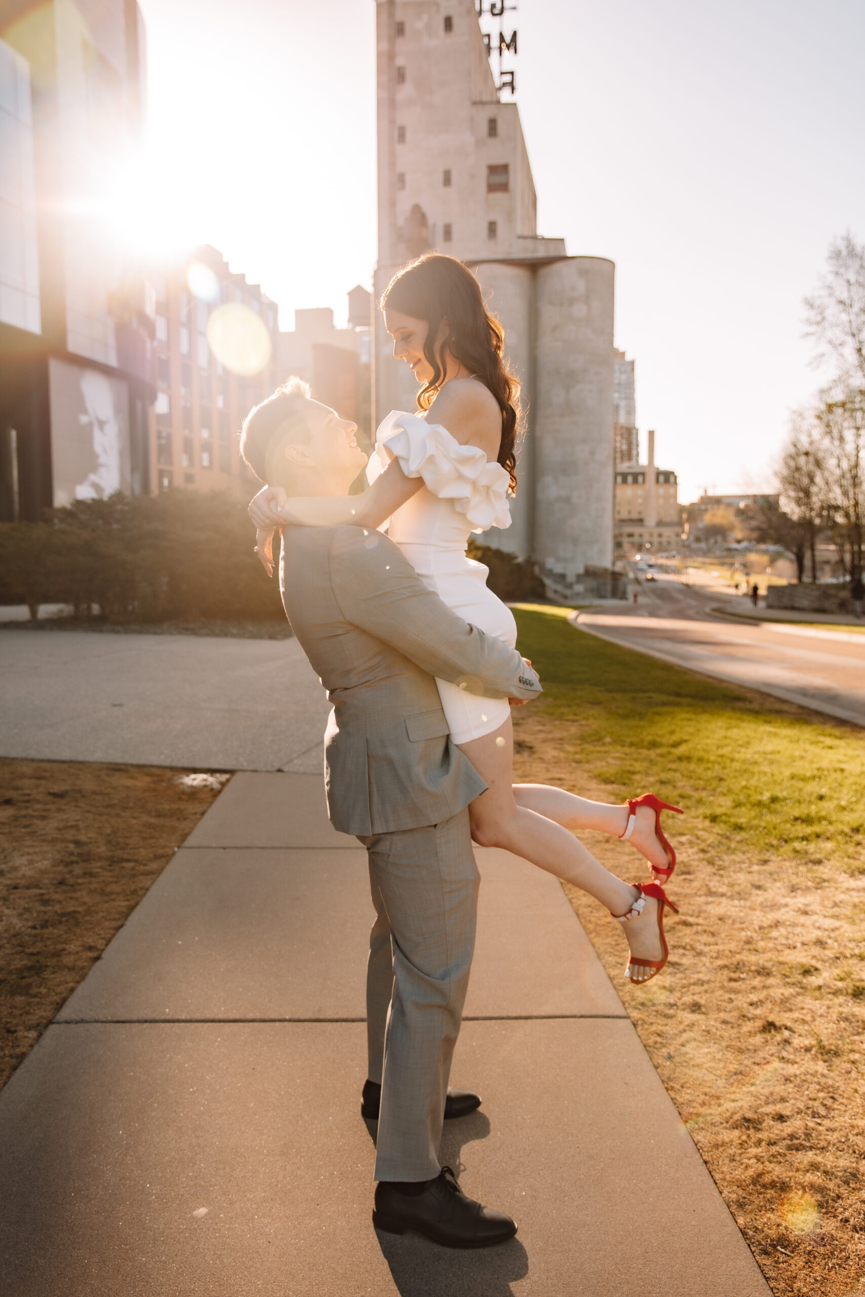 Newly engaged couple in fancy engagement outfits in the summer at Mill City Museum in Minneapolis