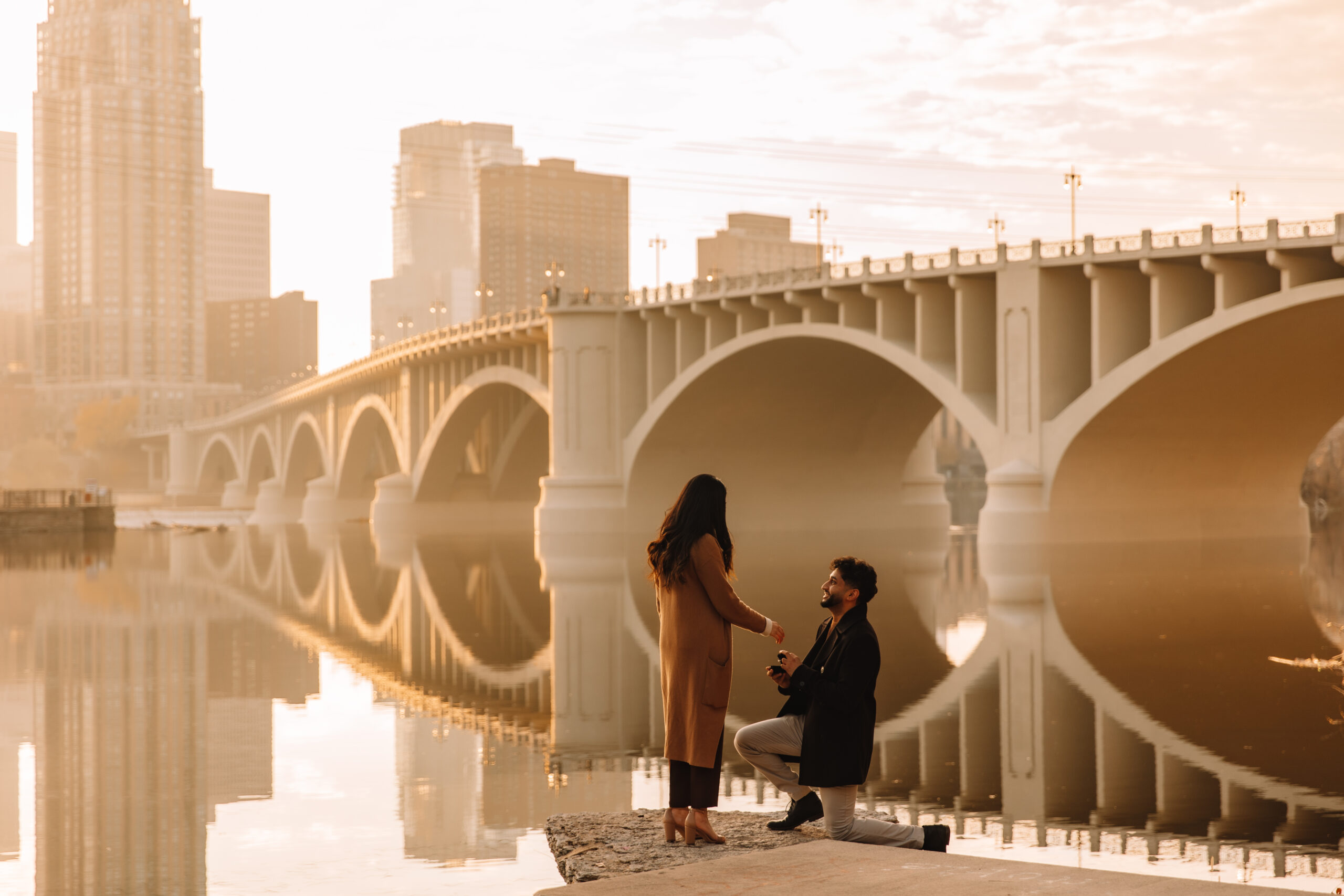 Couple promising next to the Boston bridge in Fall