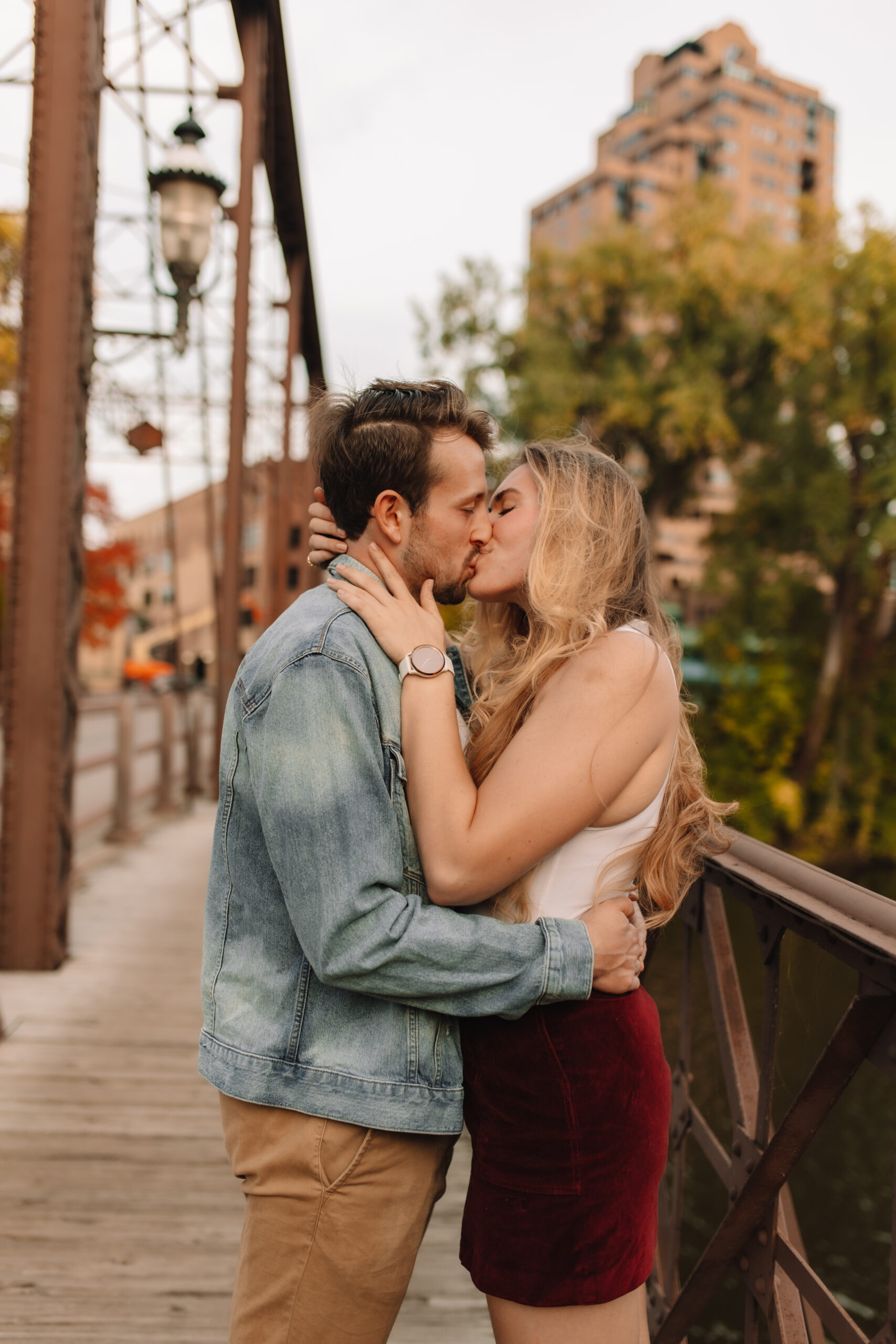 Newly engaged couple kissing on a bridge in Minnesota