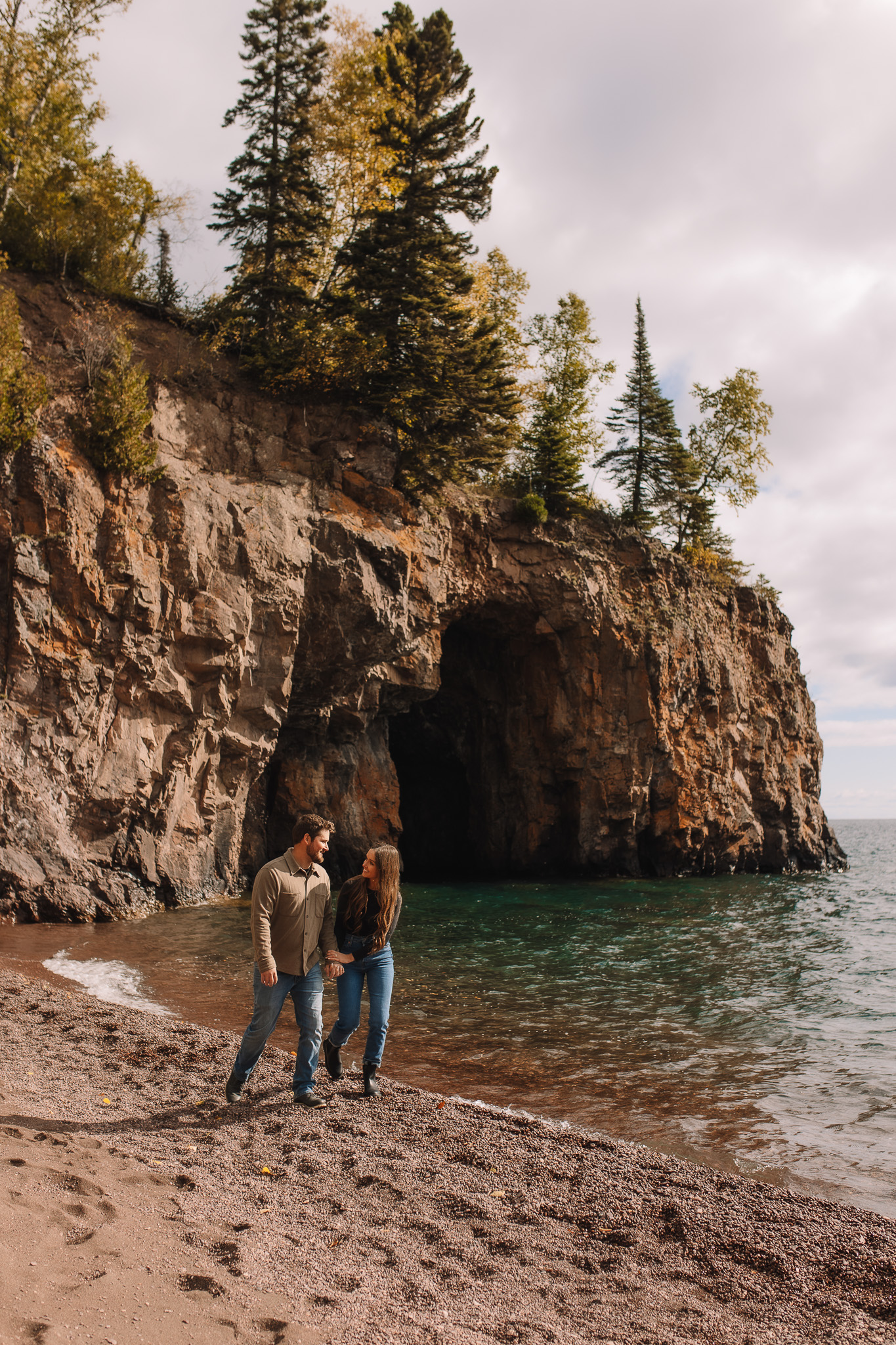 Newly engaged couple wearing casual engagement outfits for their beach engagement in Minnesota