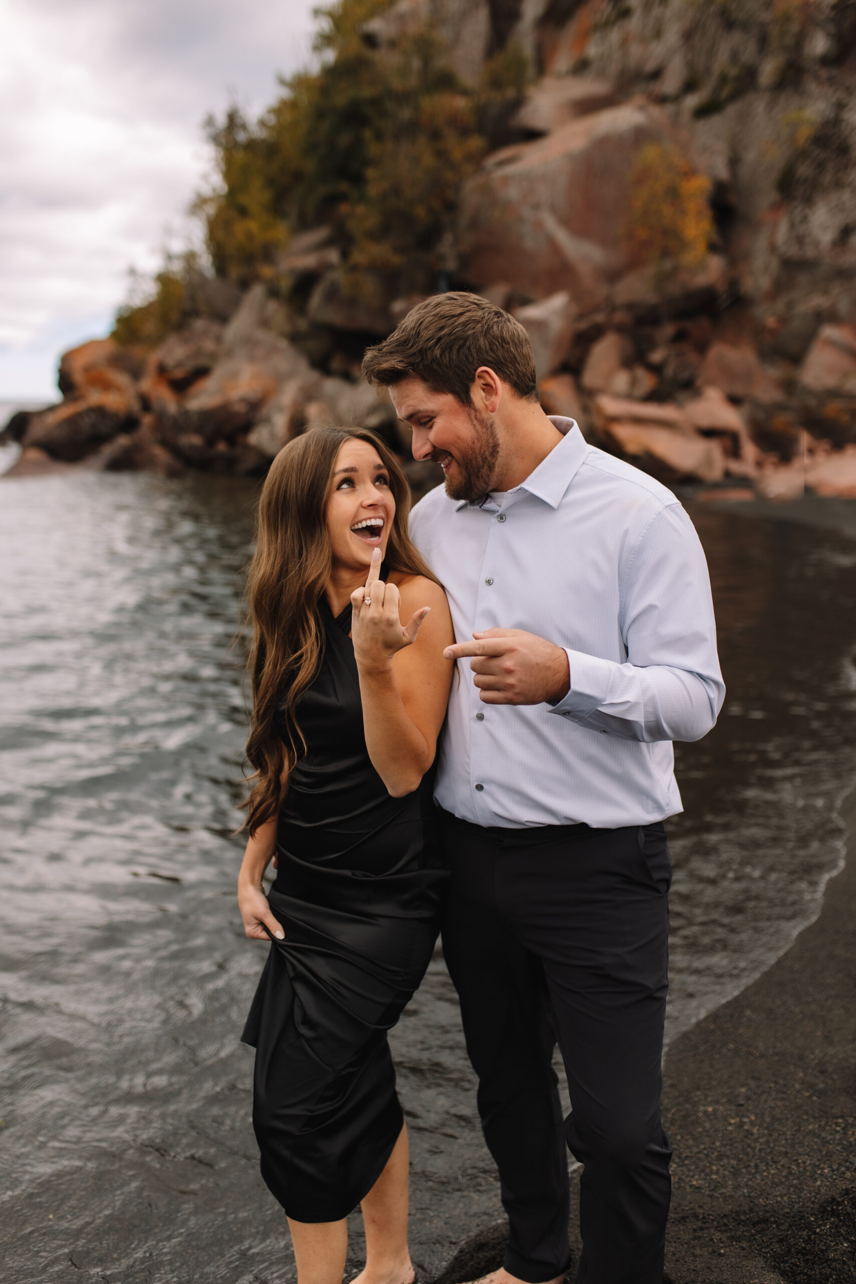 Newly engaged couple wearing formal engagement outfits for their beach engagement