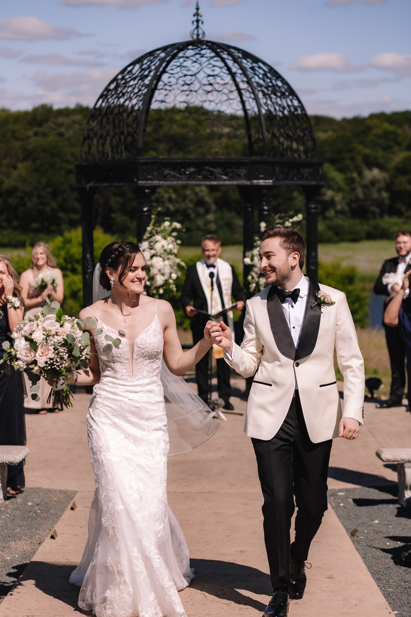 Bride and groom smiling walking up the ceremony aisle at the Edward Anne Estate Wedding venue