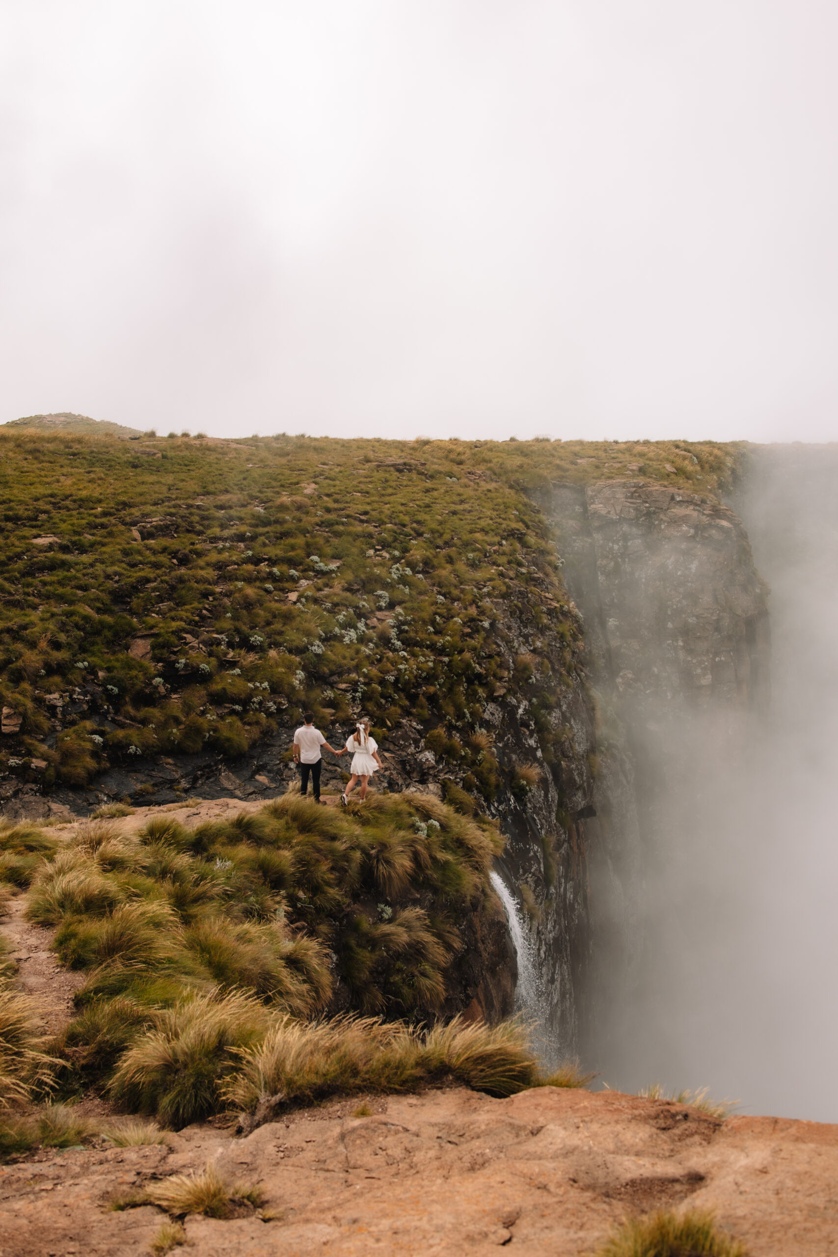 Elopement couple walking towards the top of Tugela falls in South Africa