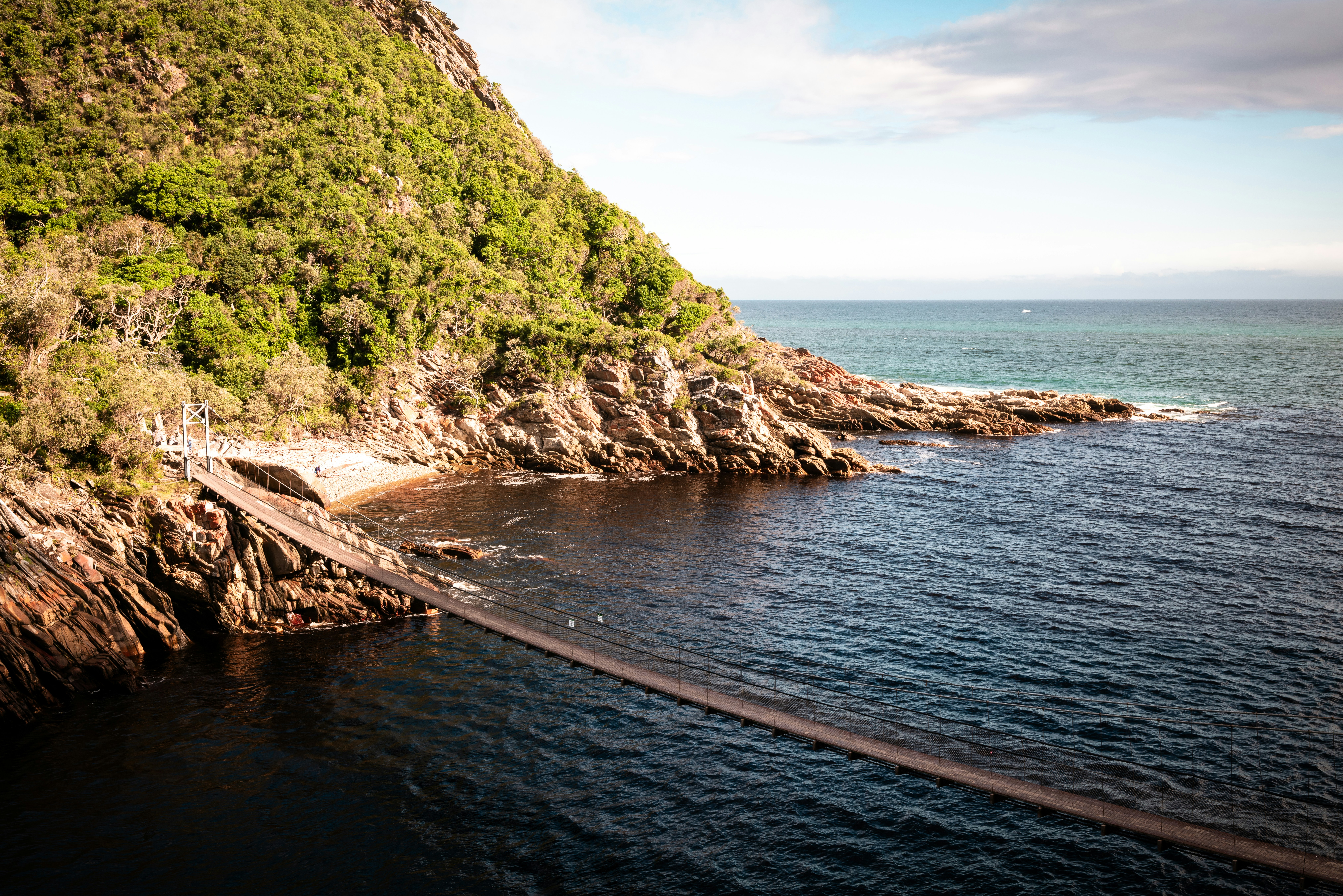 Elopement spot along the garden route in South Africa called Tsitsikamma Nature reserve. A long bridge stretches over the blue ocean from mountain to mountain