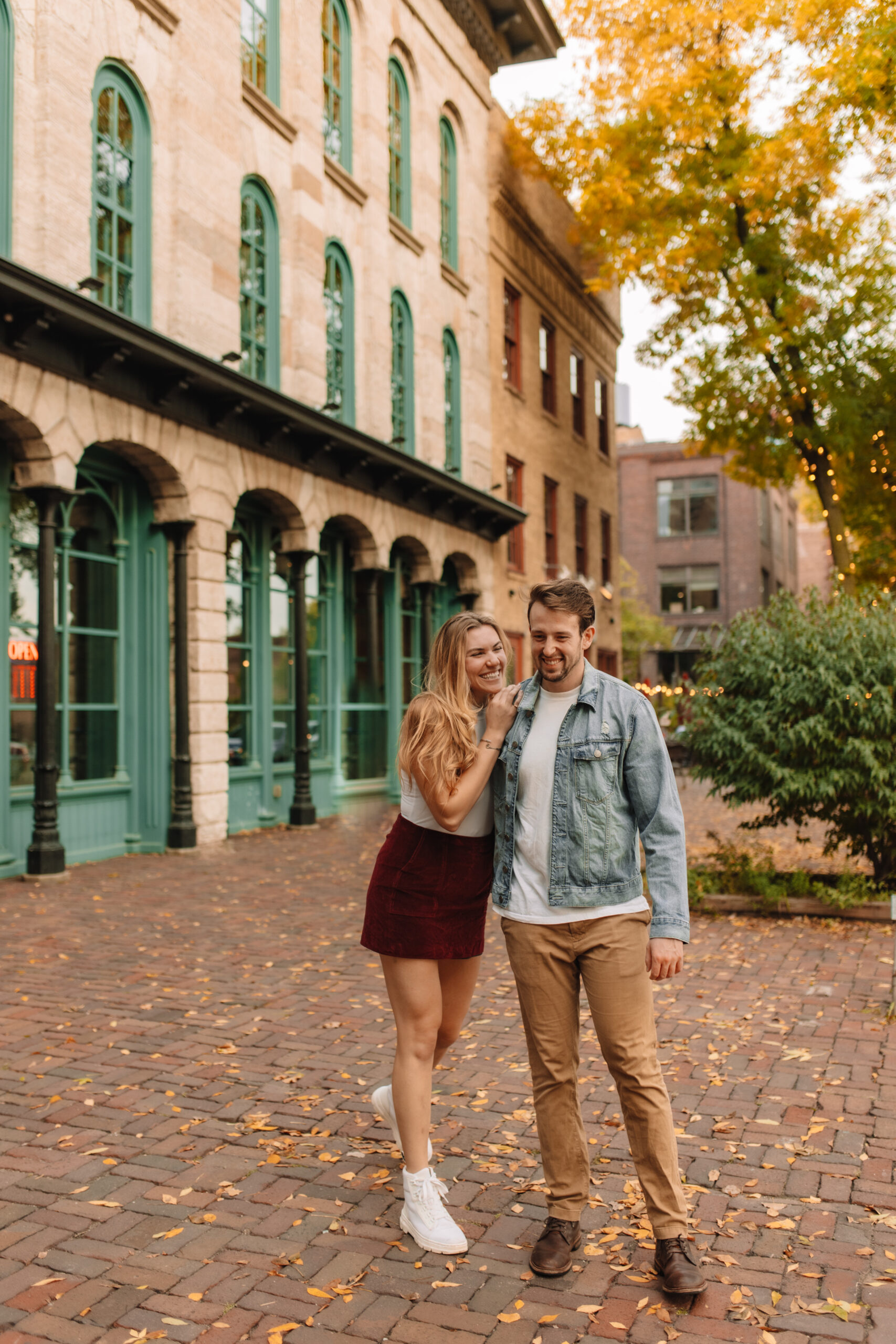 Newly engaged couple walking cobblestone streets in Minnesota