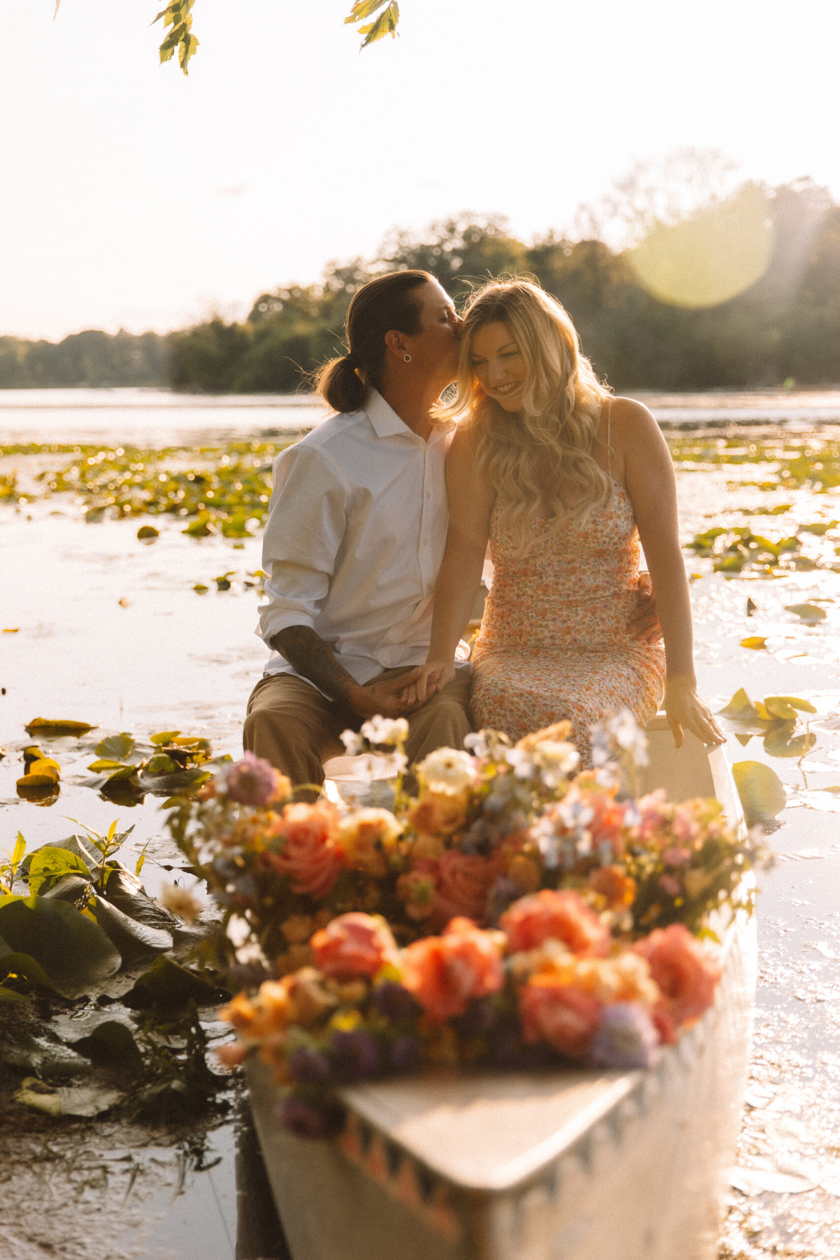 Newly engaged couple sitting in a canoe full of flowers