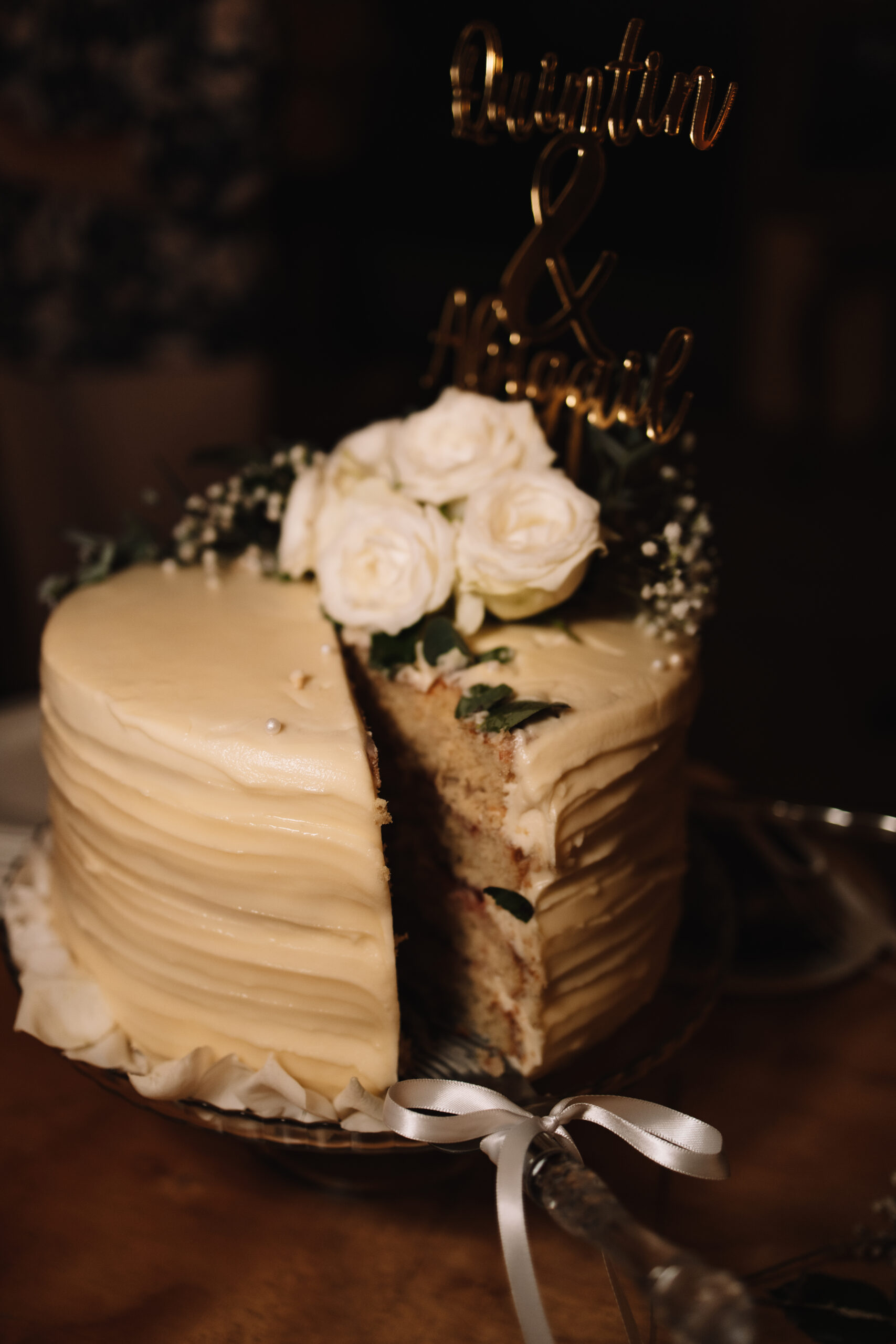 Delicious white wedding cake with white roses on the top