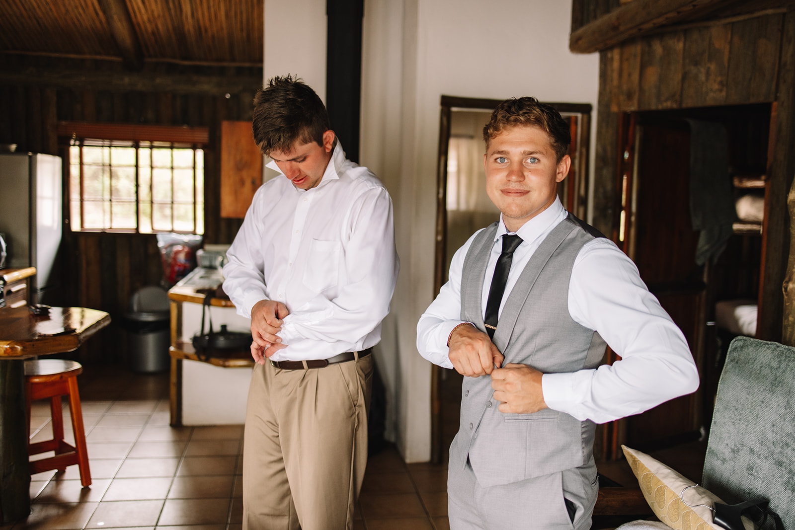 Groom getting ready in a sleeper chalet at Lake Eland for his destination wedding in South Africa