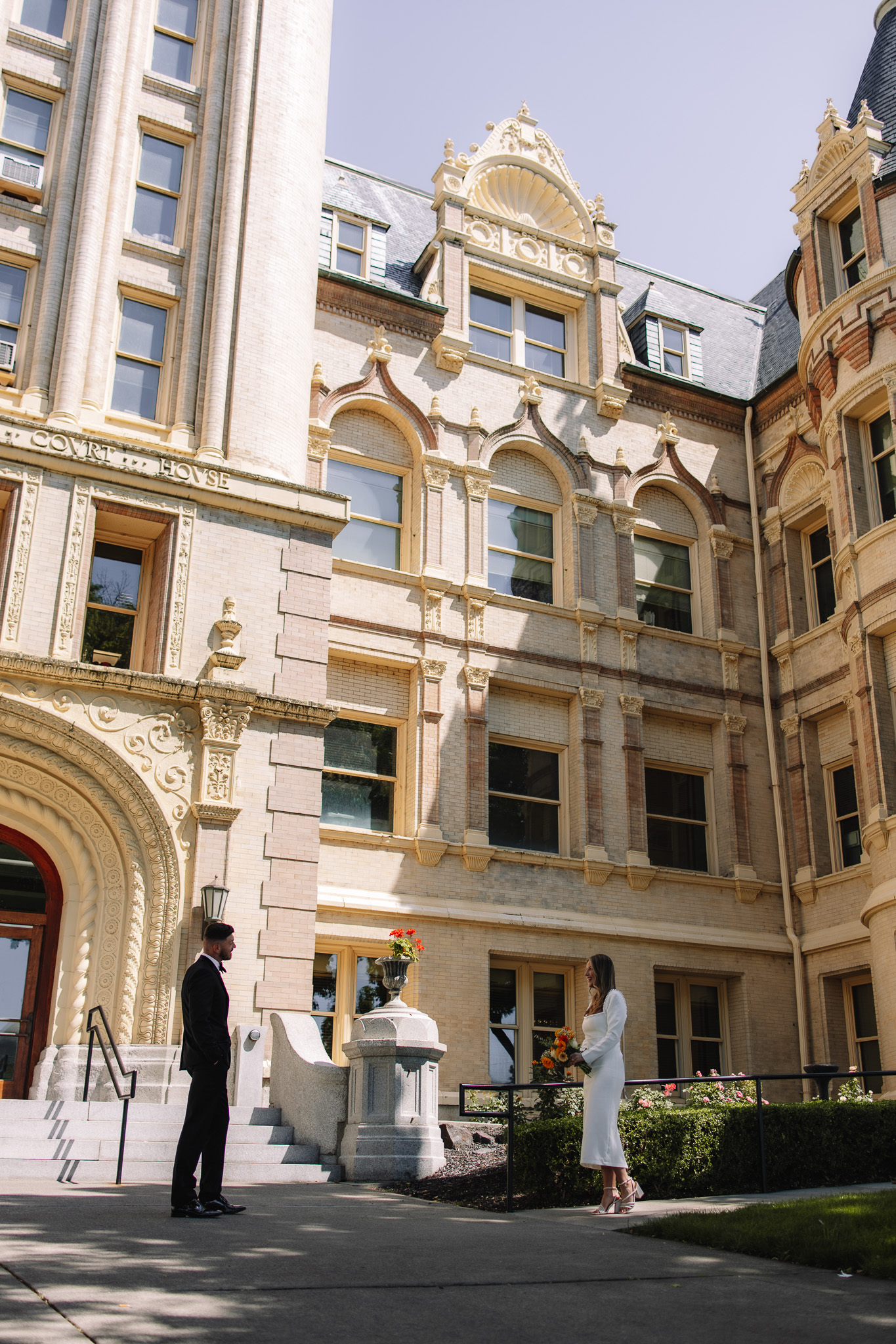 First look between bride in groom in front of a beautiful courthouse in Minnesota