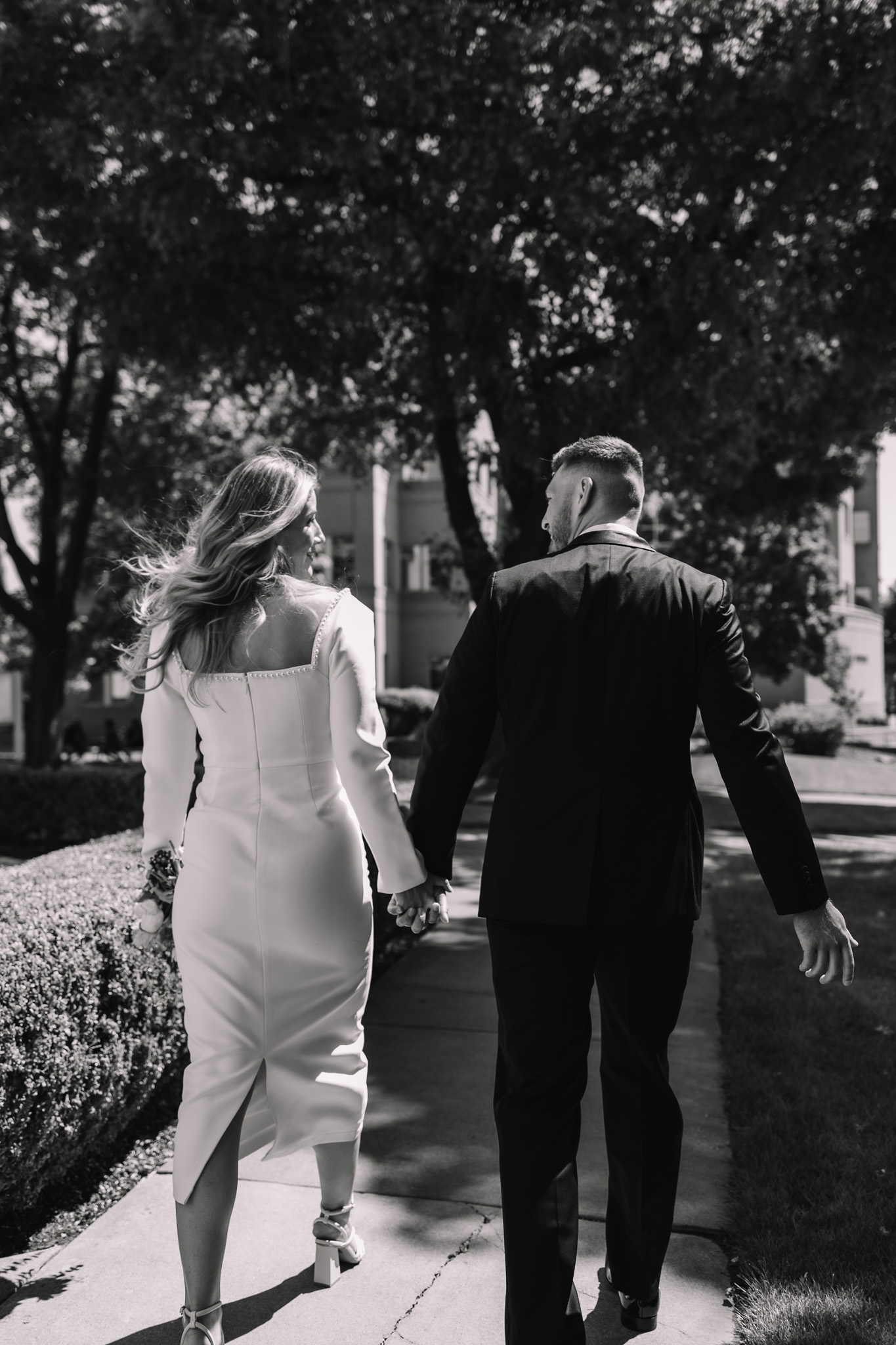 Black and white photo of Bride and groom walking together 