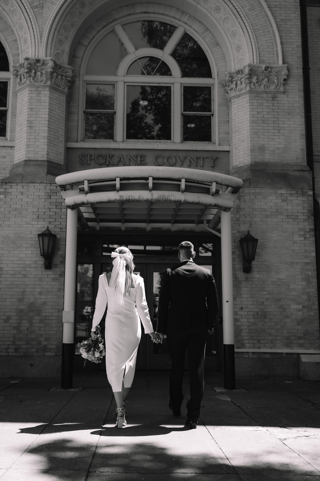 Bride and groom walking together towards a courthouse in Minnesota